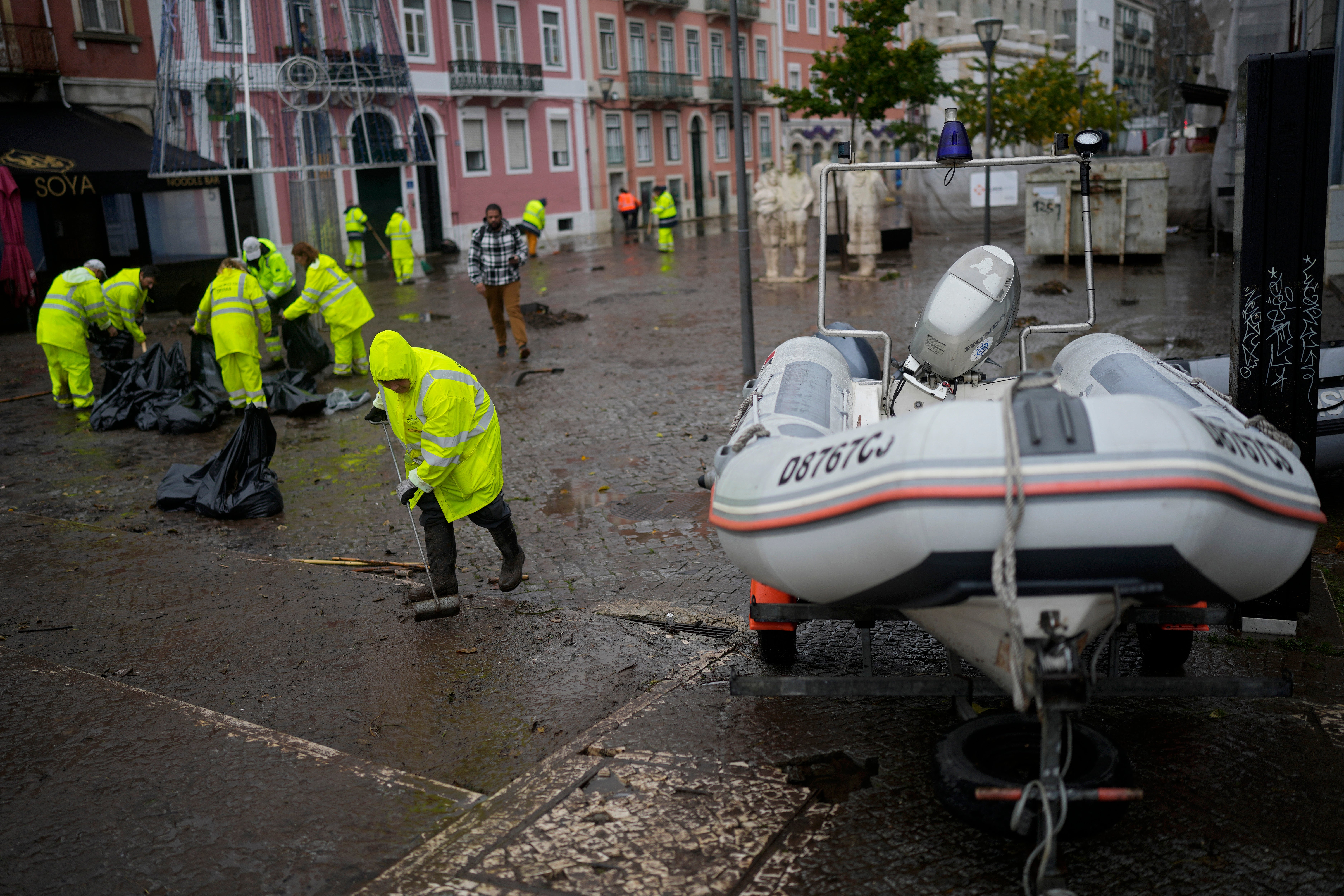 Europe Climate Municipal workers clean a street that was flooded in Alges, just outside Lisbon