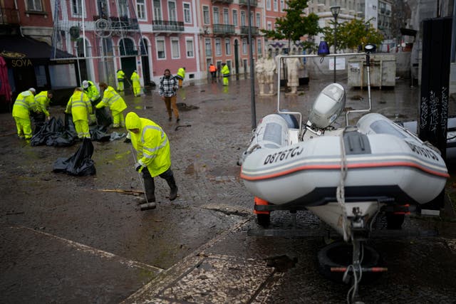 <p>Europe Climate Municipal workers clean a street that was flooded in Alges, just outside Lisbon</p>