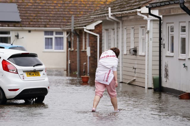 A resident wades through flood water in Littlehampton (Gareth Fuller/PA)