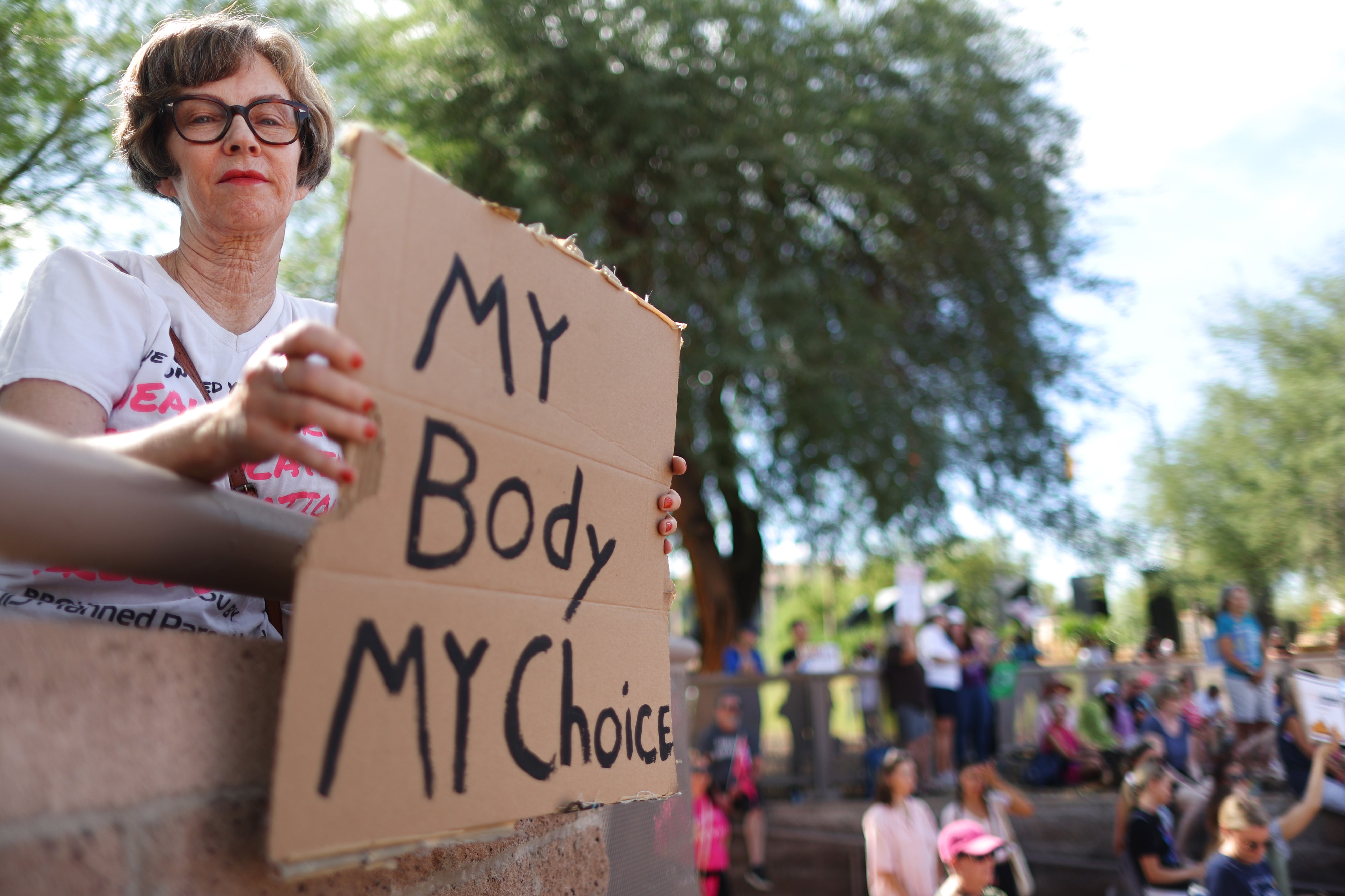 A protester holds a sign reading ‘My Body My Choice’ at a women’s march rally outside the State Capitol on 8 October 2022 in Phoenix, Arizona