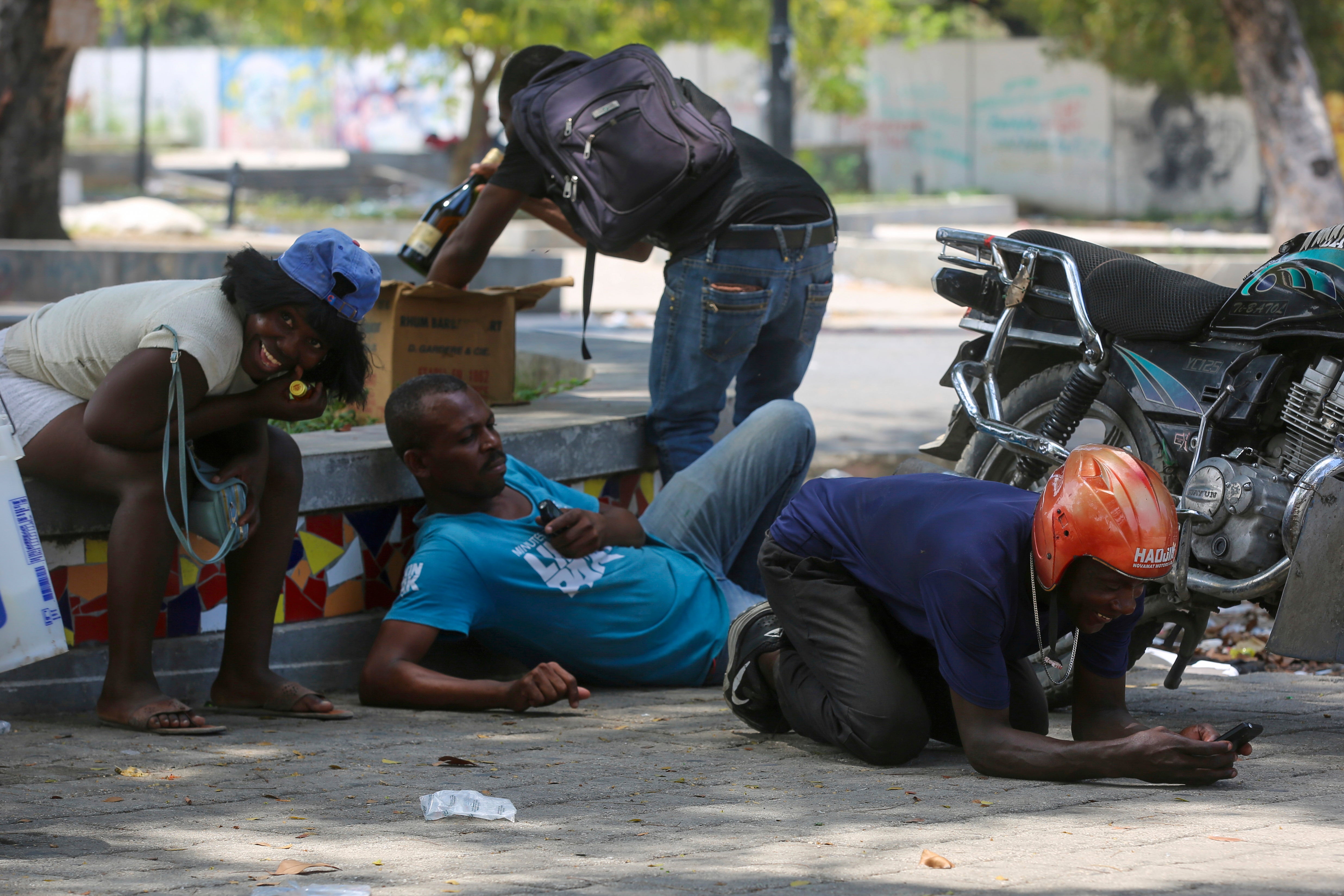 Haiti ViolencePeople take cover from gunfire during clashes between police and gangs in the Champs de Mars area