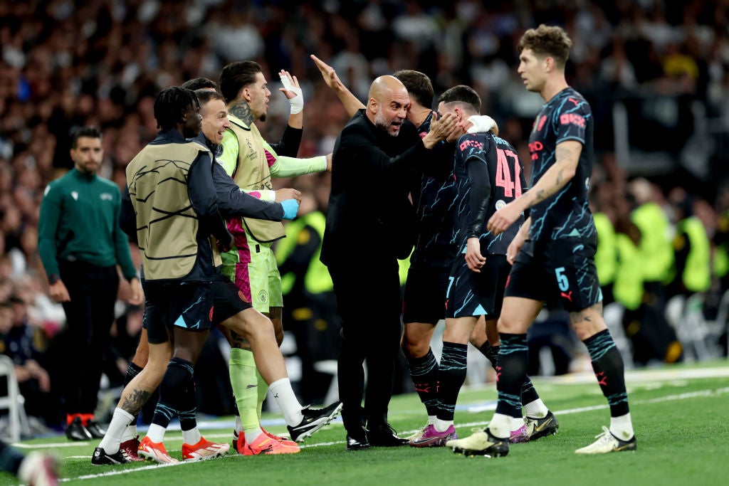 Pep Guardiola celebrates with Phil Foden and Ruben Dias