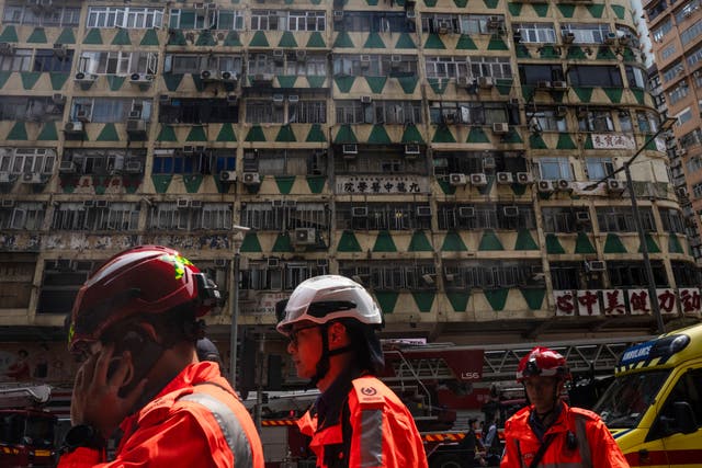 <p>Firefighters walk past a building called New Lucky House where a fire started in Hong Kong, Wednesday, 10 April 2024</p>