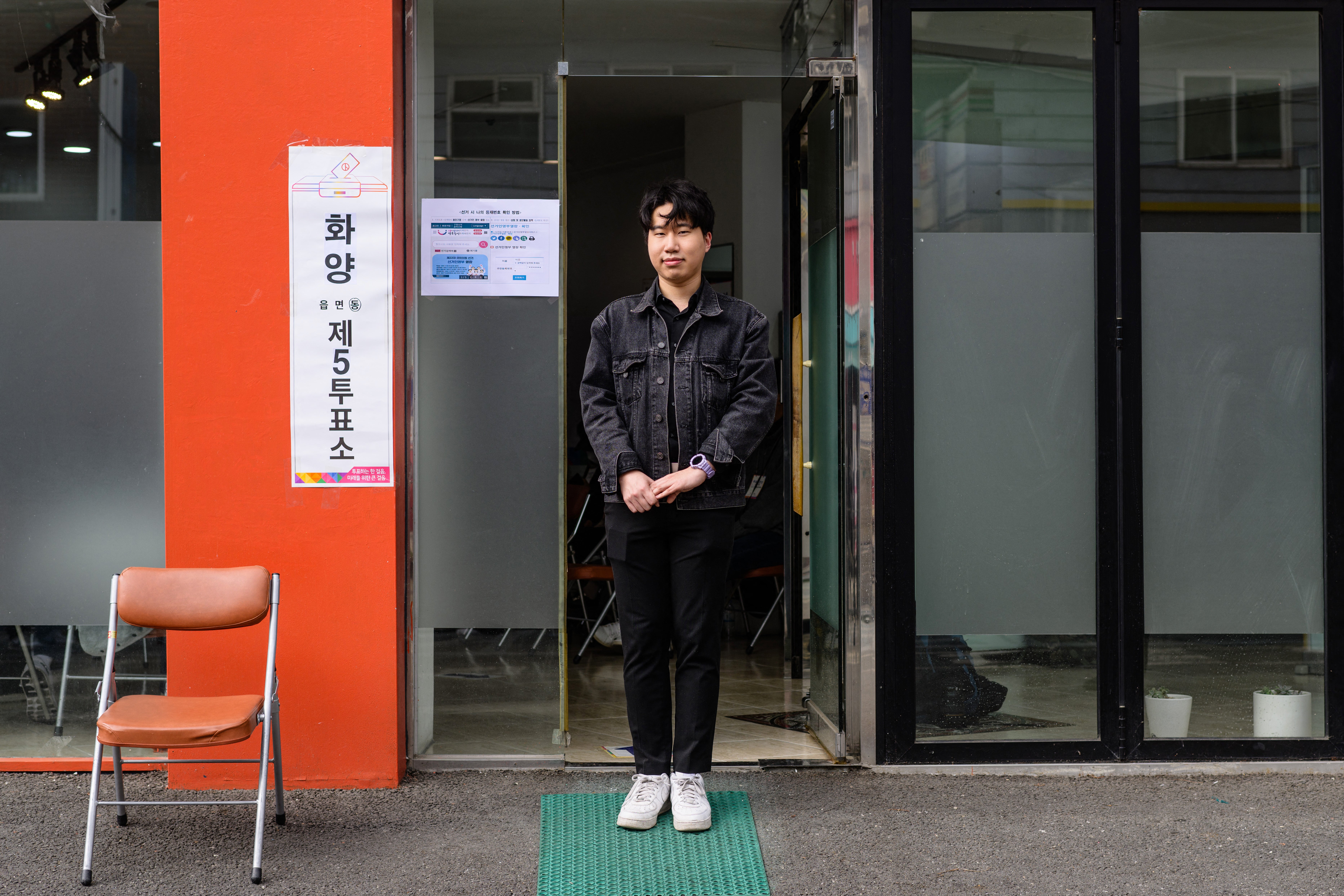Kim Yong-ho, 24, who owns a food and beverages business, poses outside a polling station in Seoul on 10 April 2024, after voting for the first time, during the parliamentary election