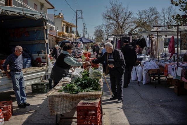 <p>People shop at the local open market in the village of Dikaia, in the remote crop-growing area bordering Turkey and Bulgaria </p>