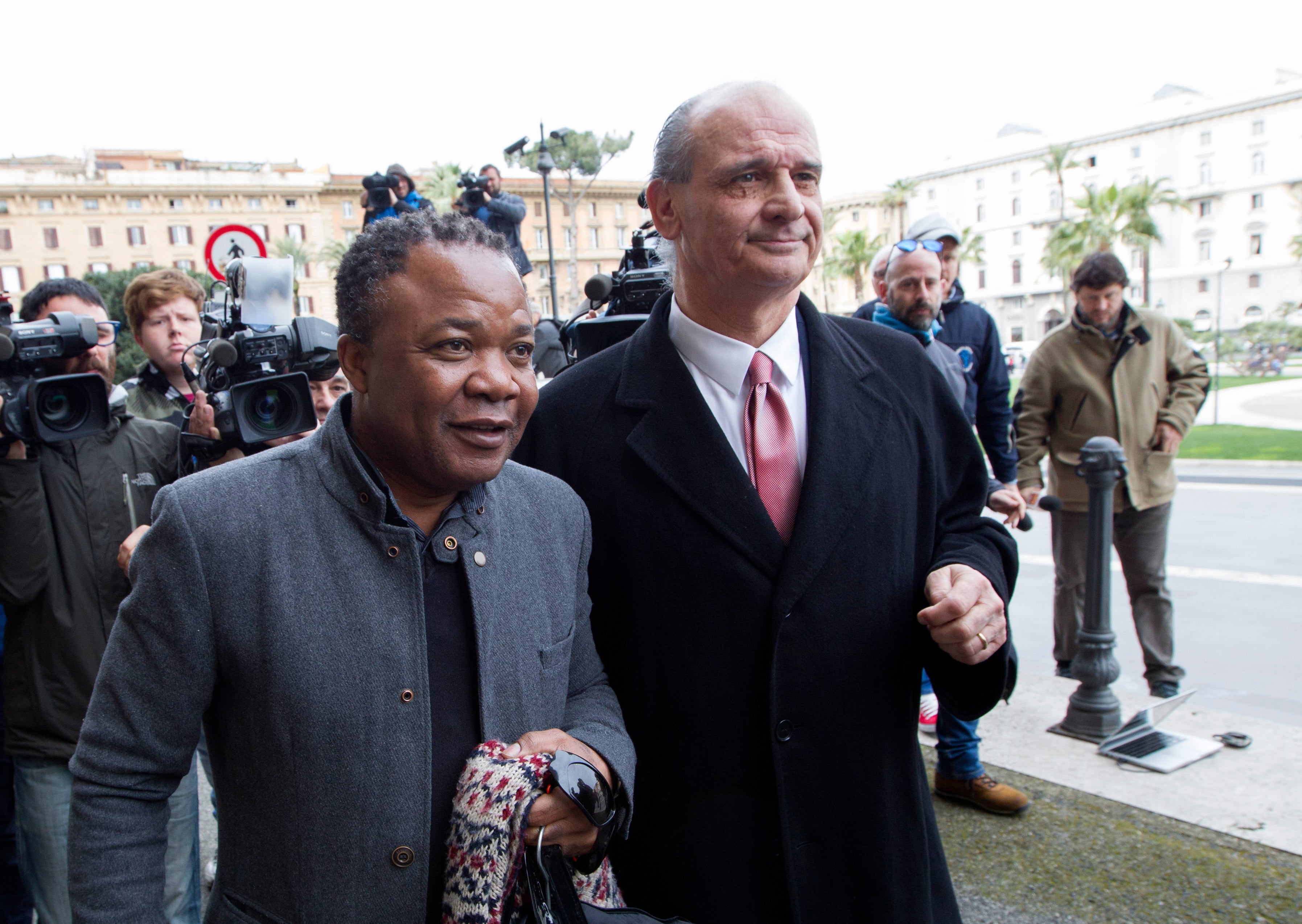 Patrick Lumumba, left, flanked by his lawyer Carlo Pacelli, outside an earlier hearing in Rome