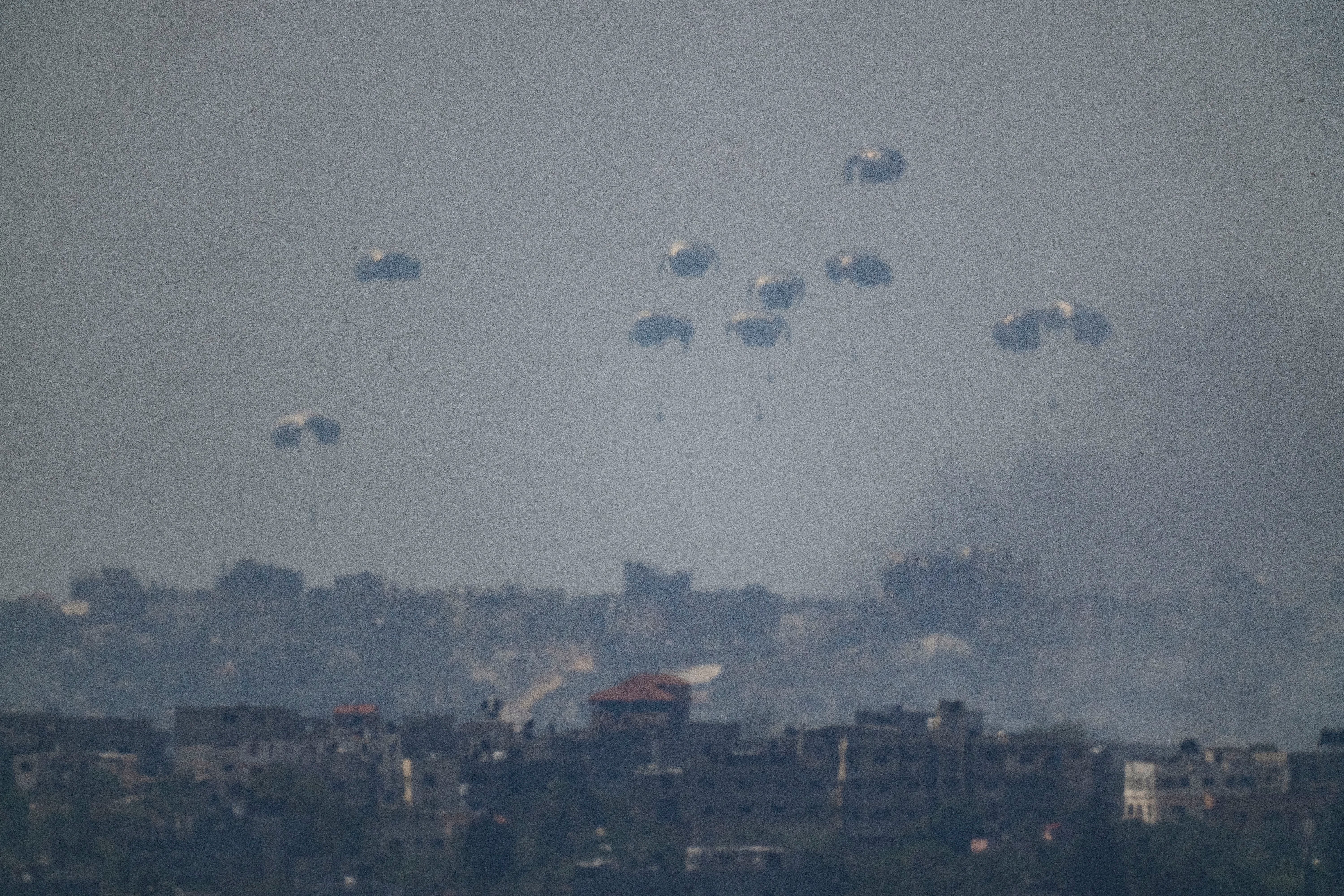 Parachutes drop supplies into the northern Gaza Strip as seen from southern Israel, Tuesday, April 9, 2024.