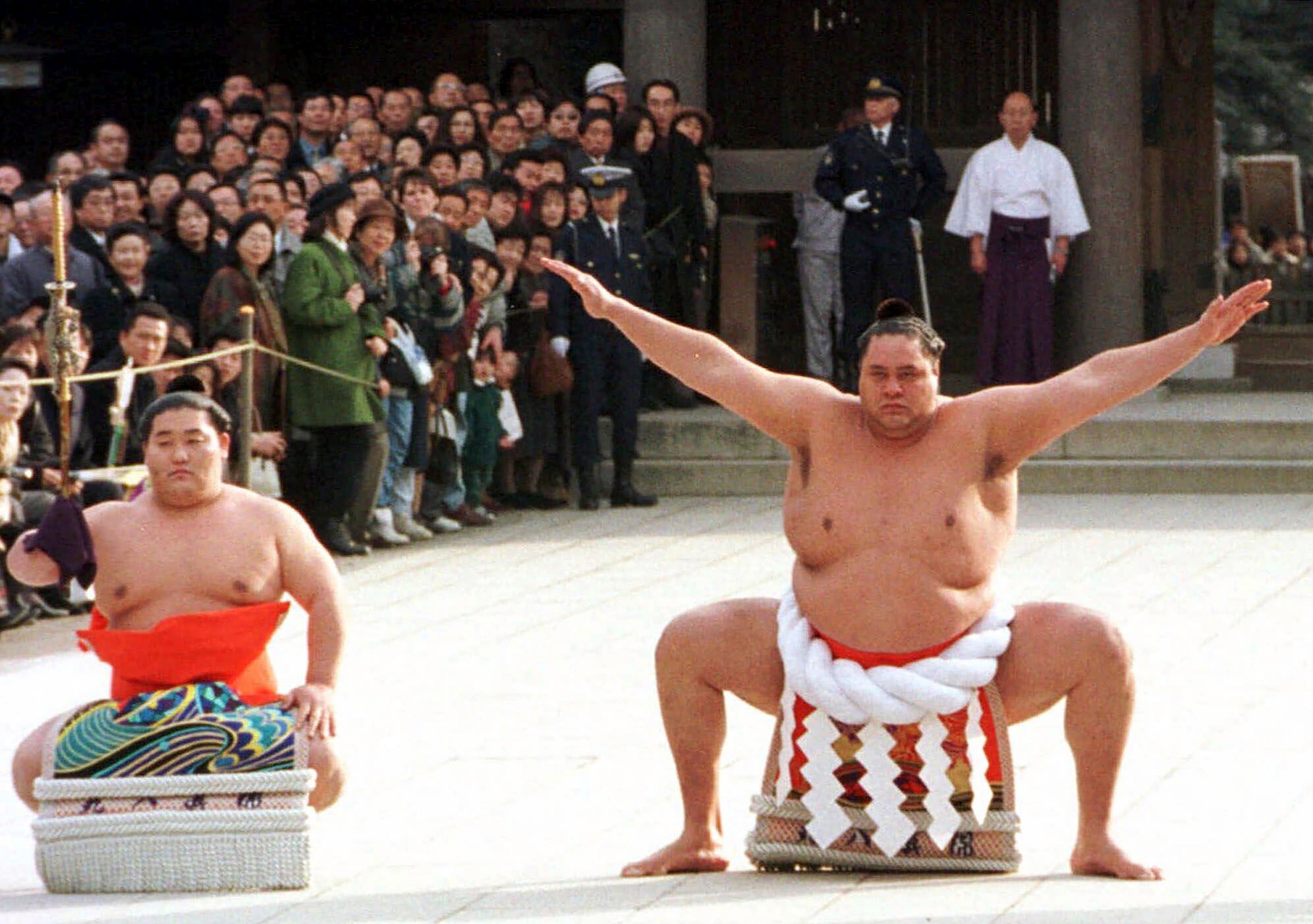Accompanied by a sword-bearer, grand champion Akebono performs the ring-entrance ritual during the annual New Year's dedication at Meiji Shrine in Tokyo, on Jan. 8, 1997