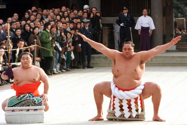 <p>Accompanied by a sword-bearer, grand champion Akebono performs the ring-entrance ritual during the annual New Year's dedication at Meiji Shrine in Tokyo, on Jan. 8, 1997</p>
