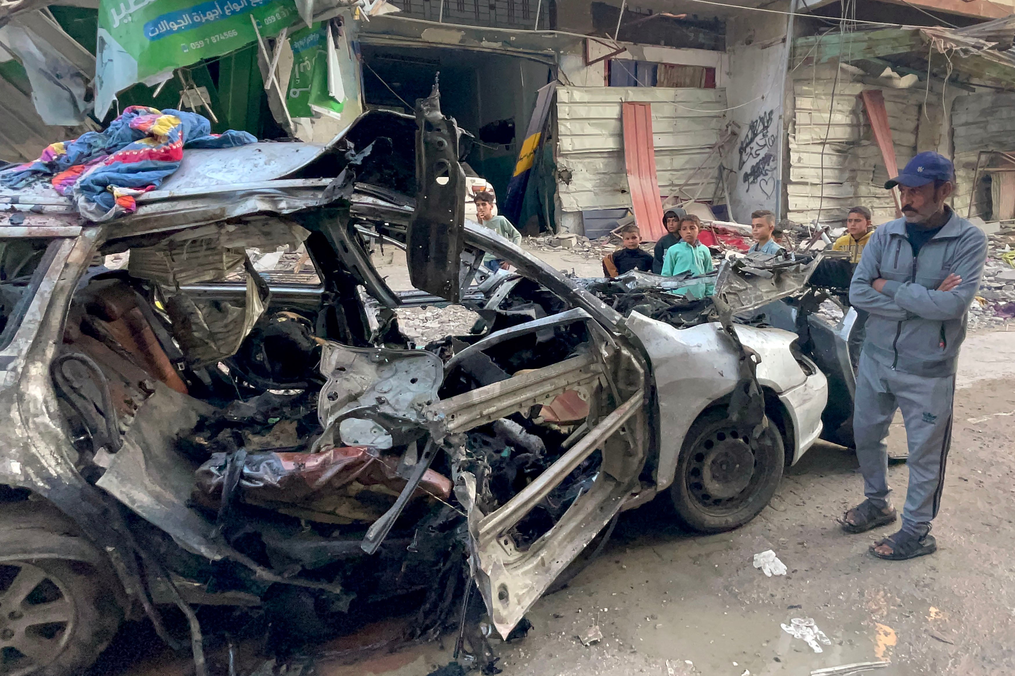 Onlookers check the car in which three sons of Hamas leader Ismail Haniyeh were reportedly killed in an Israeli air strike in al-Shati camp