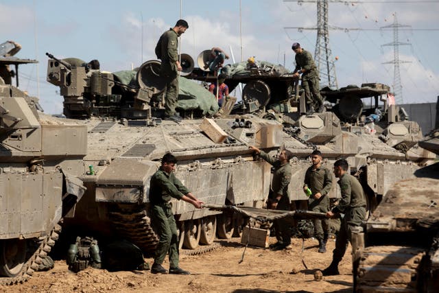 <p>Israeli soldiers  prepare their equipment and armoured personnel carriers before entering the Gaza Strip</p>