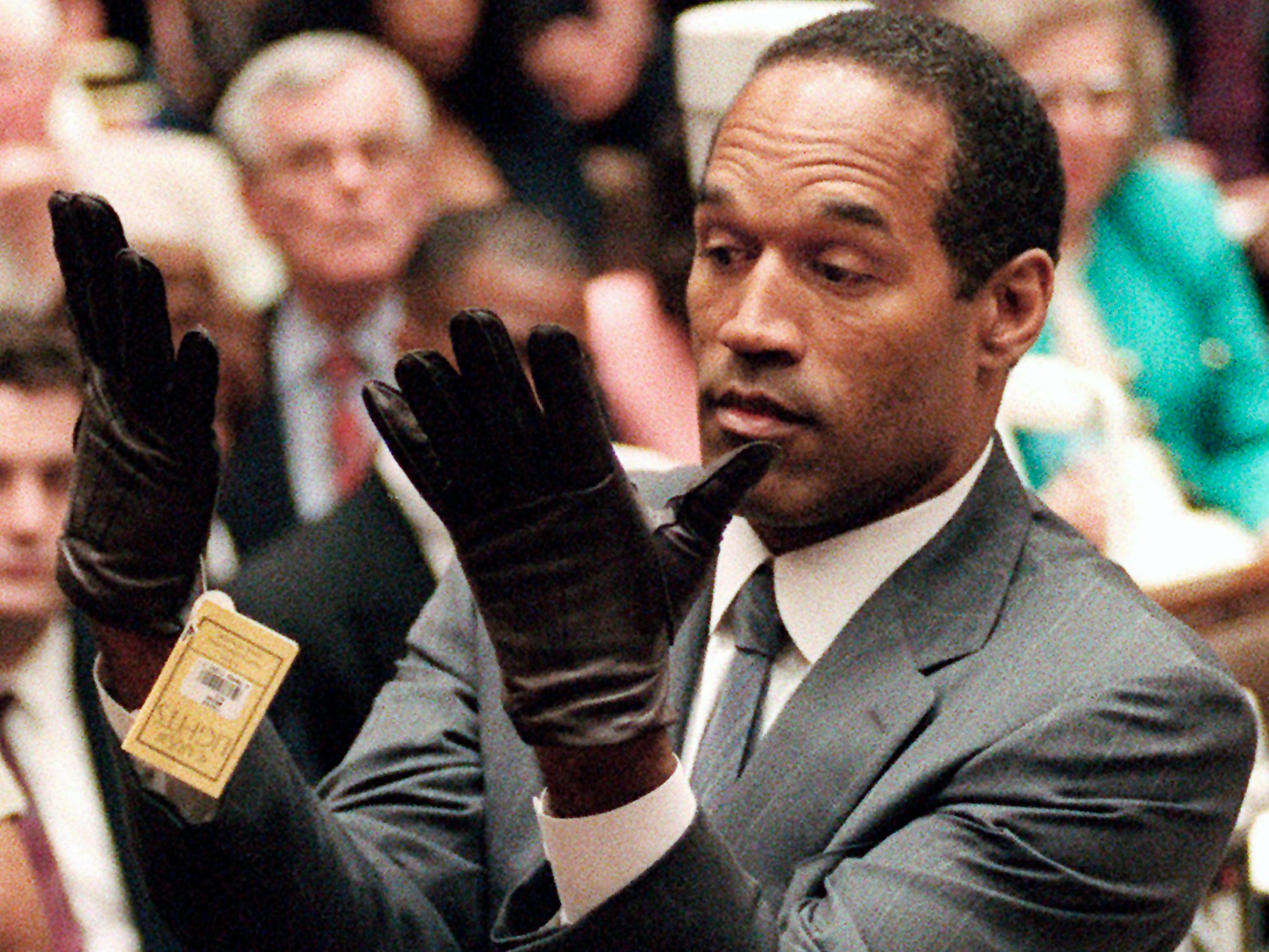 Simpson tries on gloves in court similar to those found at the murder scene