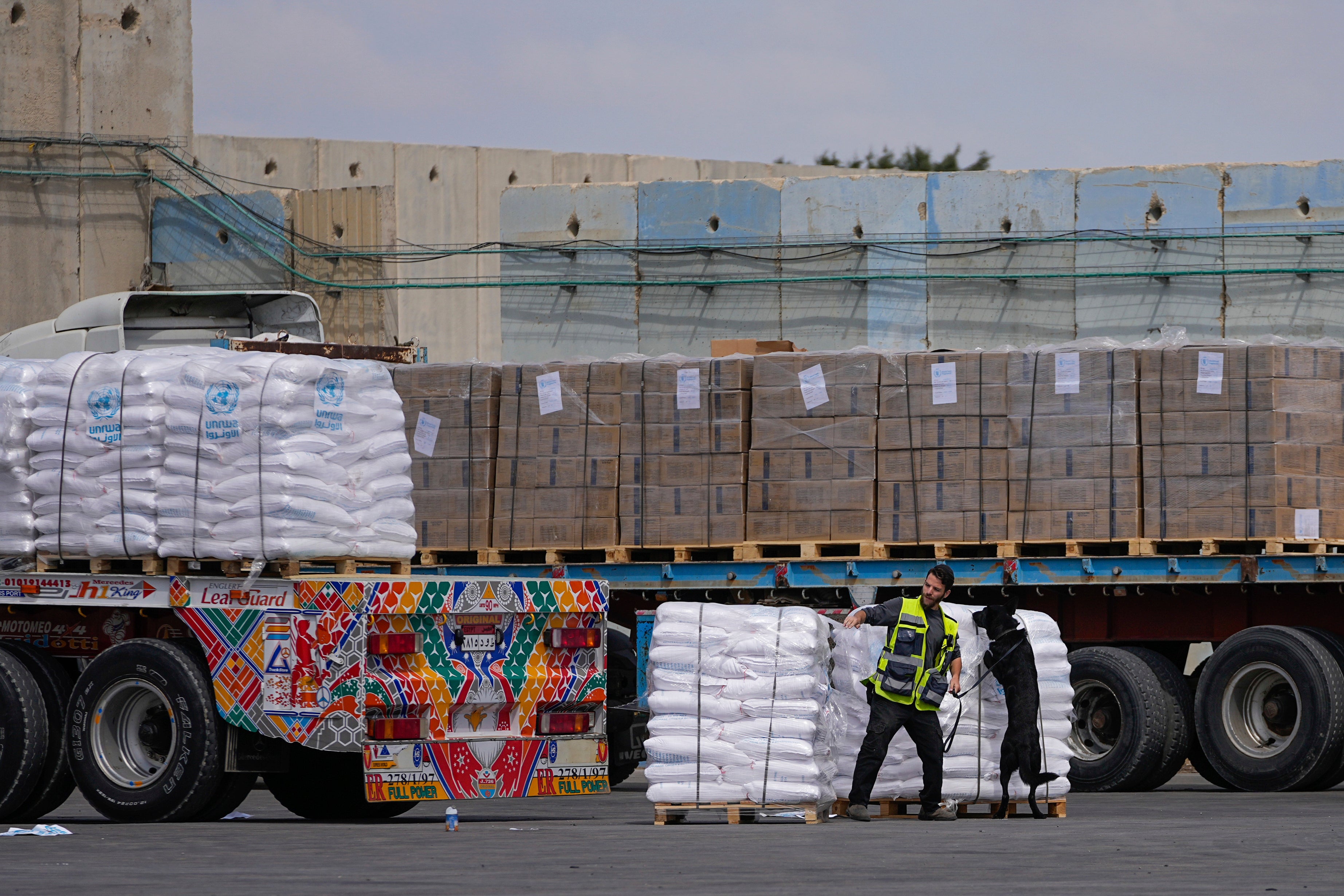 Trucks carrying humanitarian aid for the Gaza Strip pass through the inspection area at the Kerem Shalom Crossing