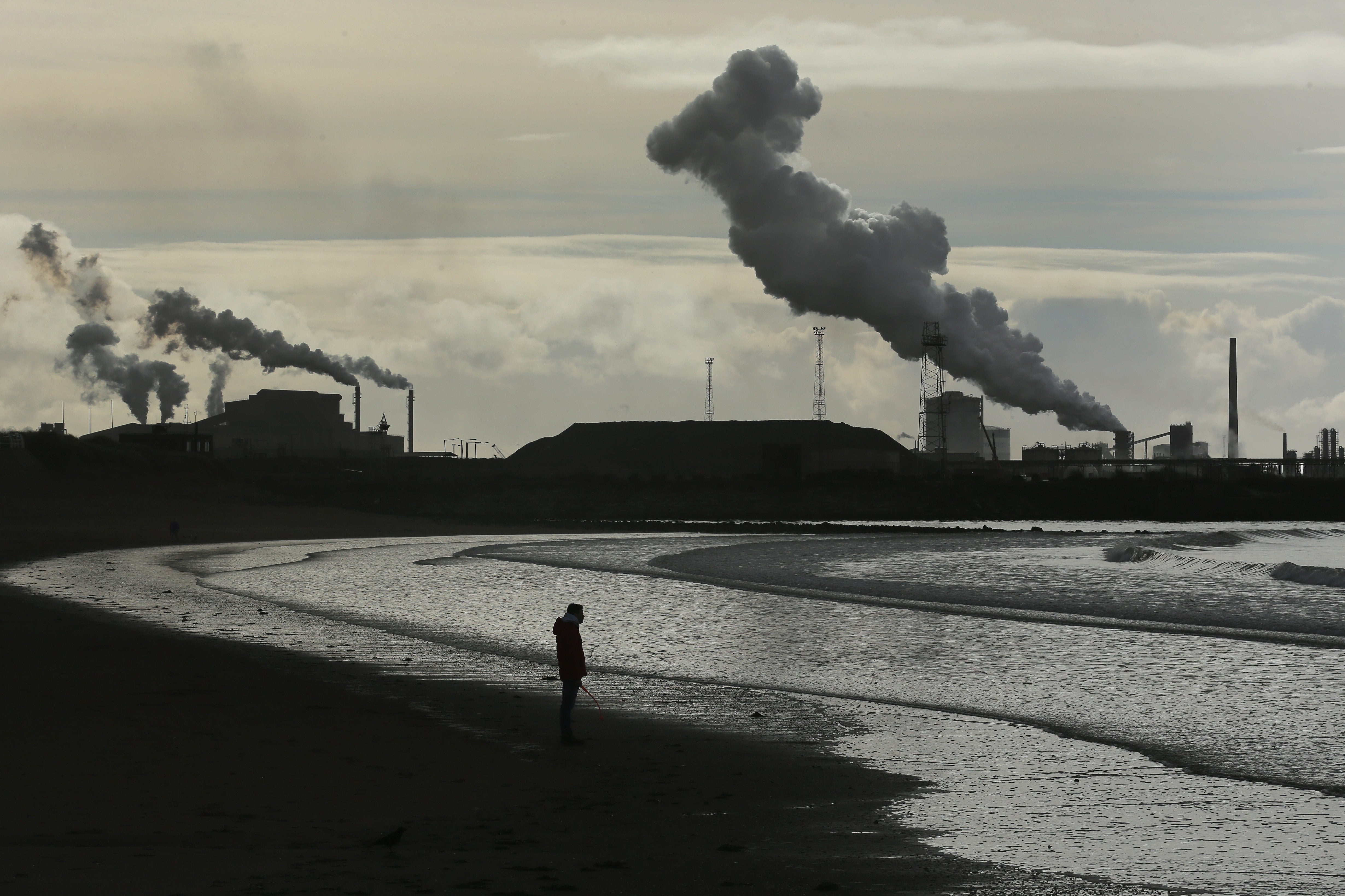 A man walks his dog on Aberavon beach near Port Talbot in Wales