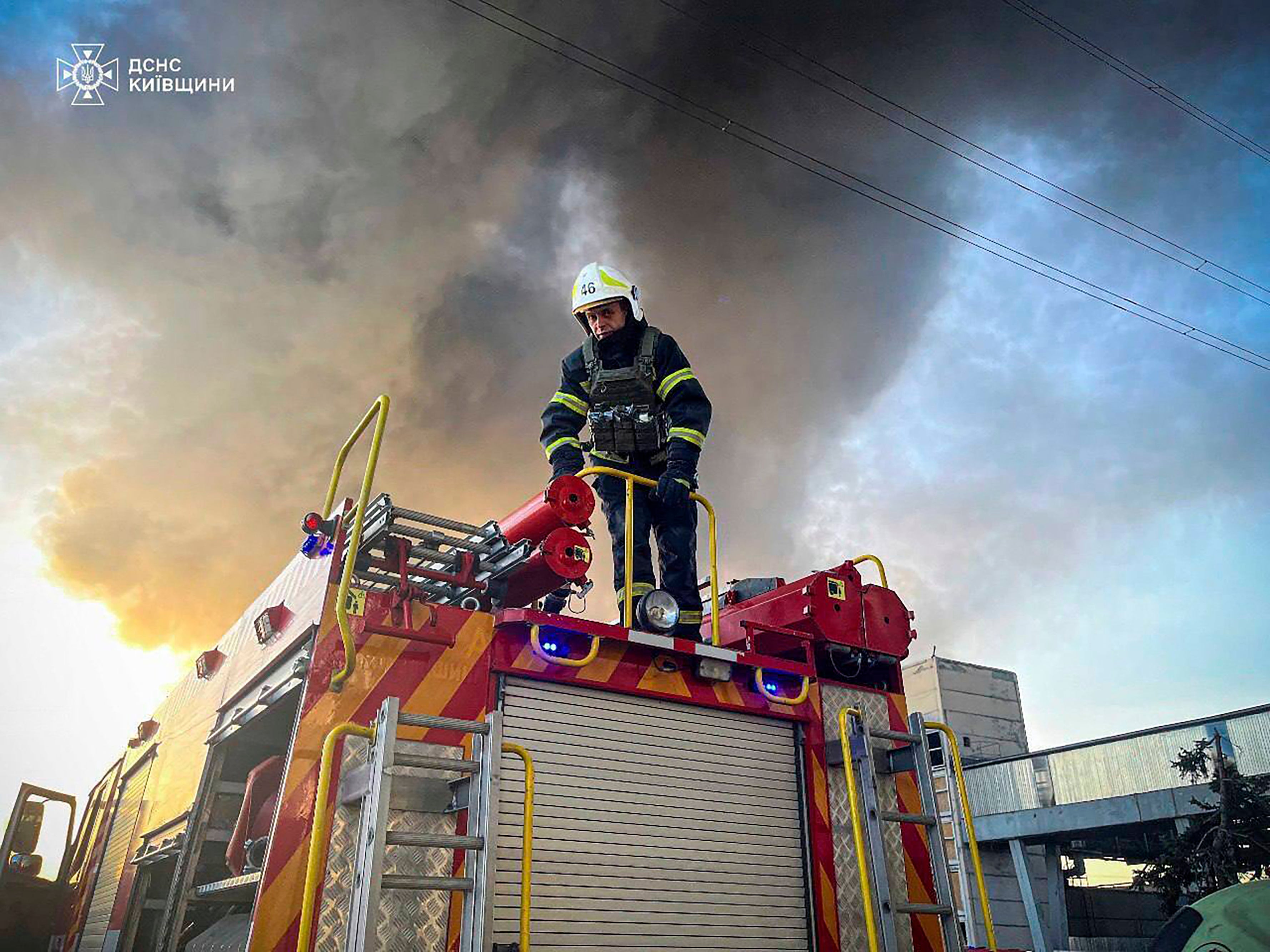 An emergency worker extinguishes a fire after a Russian attack on The Trypilska plant