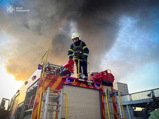 <p>An emergency worker extinguishes a fire after a Russian attack on The Trypilska plant</p>