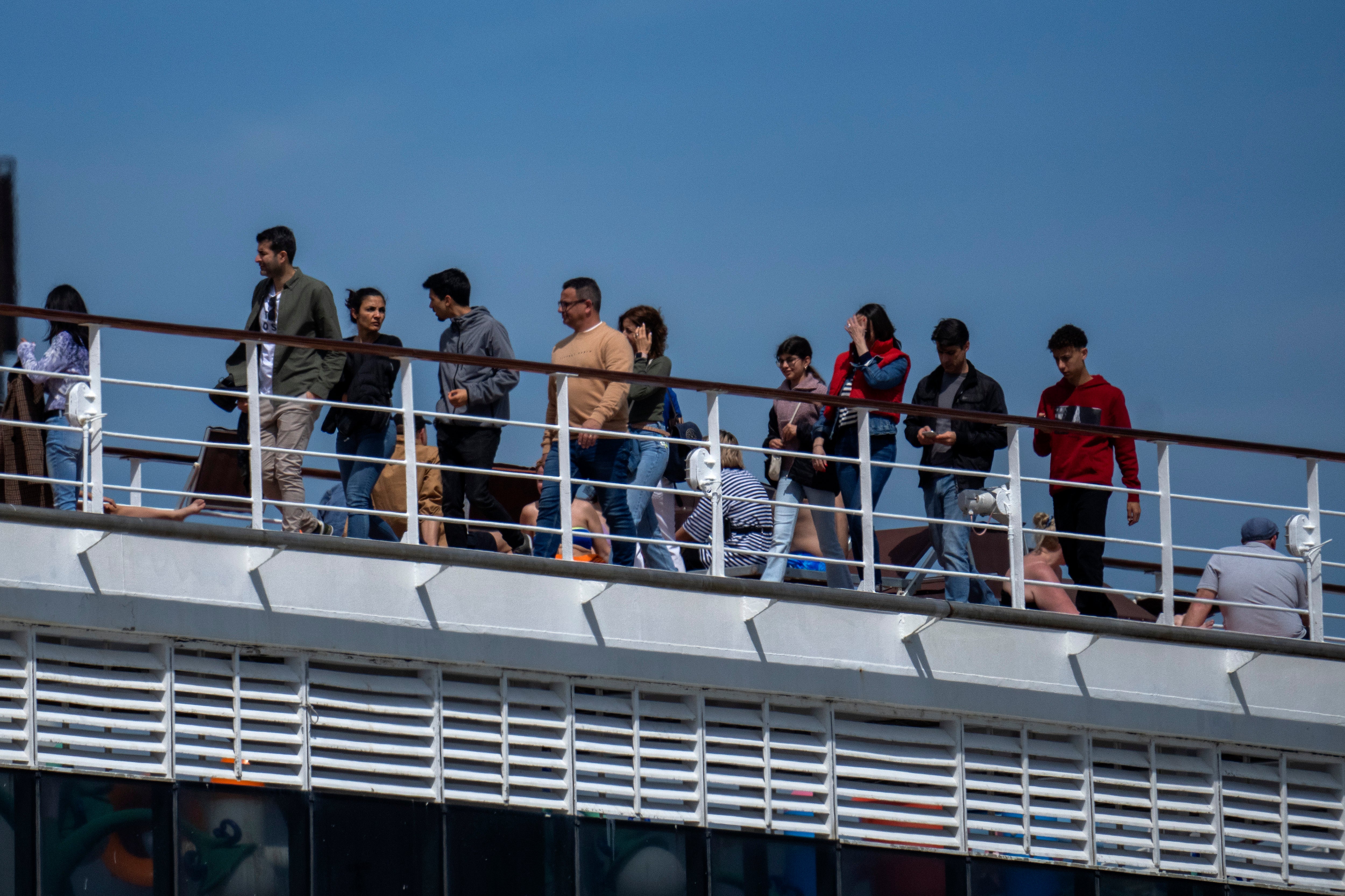 Passengers are photographed on the cruise ship moored in the port of Barcelona
