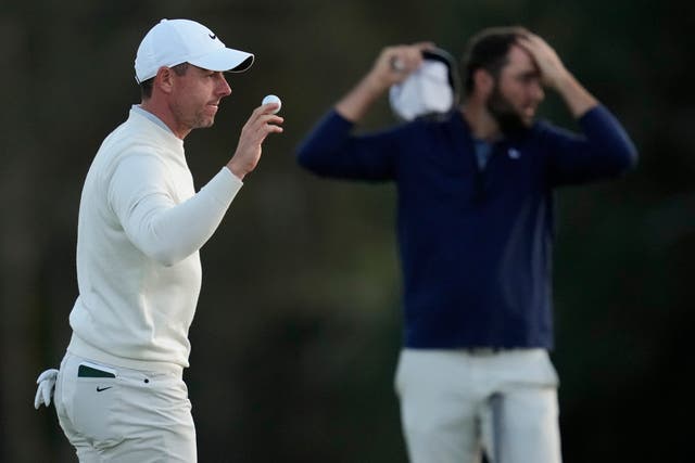 Rory McIlroy (left) trailed Scottie Scheffler (background) by 10 shots at the halfway stage of the Masters (Ashley Landis/AP)