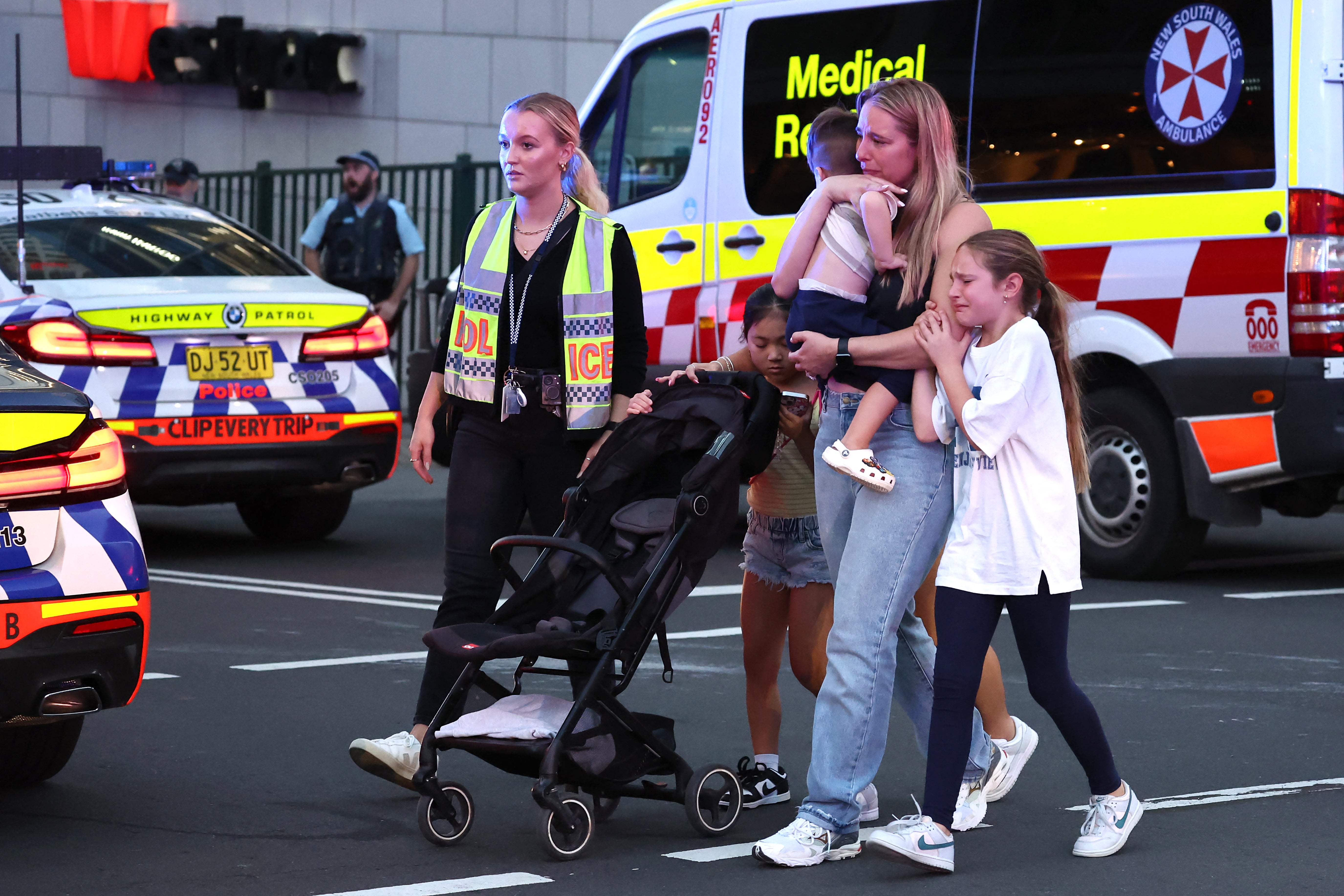 Families walk out of the Westfield Bondi Junction shopping mall after a stabbing incident in Sydney on 13 April 2024