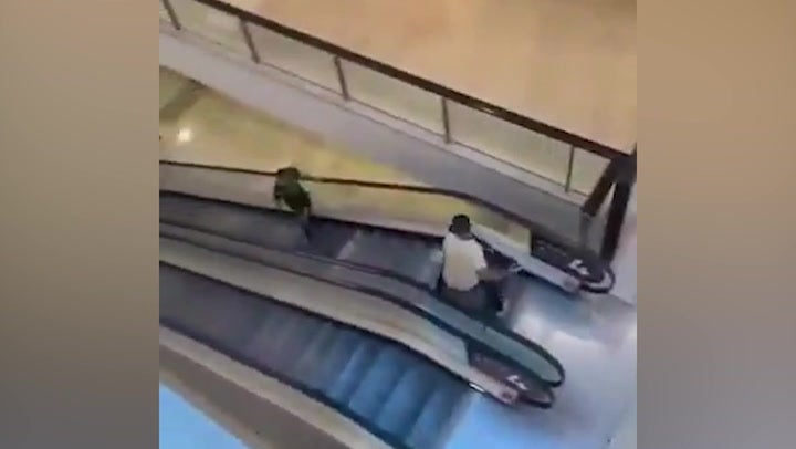 A video shows a brave shopper confronting the knifeman with a bollard on escalators inside the mall
