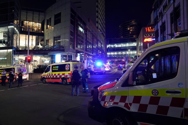 Police officers stand guard outside Westfield Shopping Centre where multiple people were stabbed in Sydney, Australia (Rick Rycroft/AP)