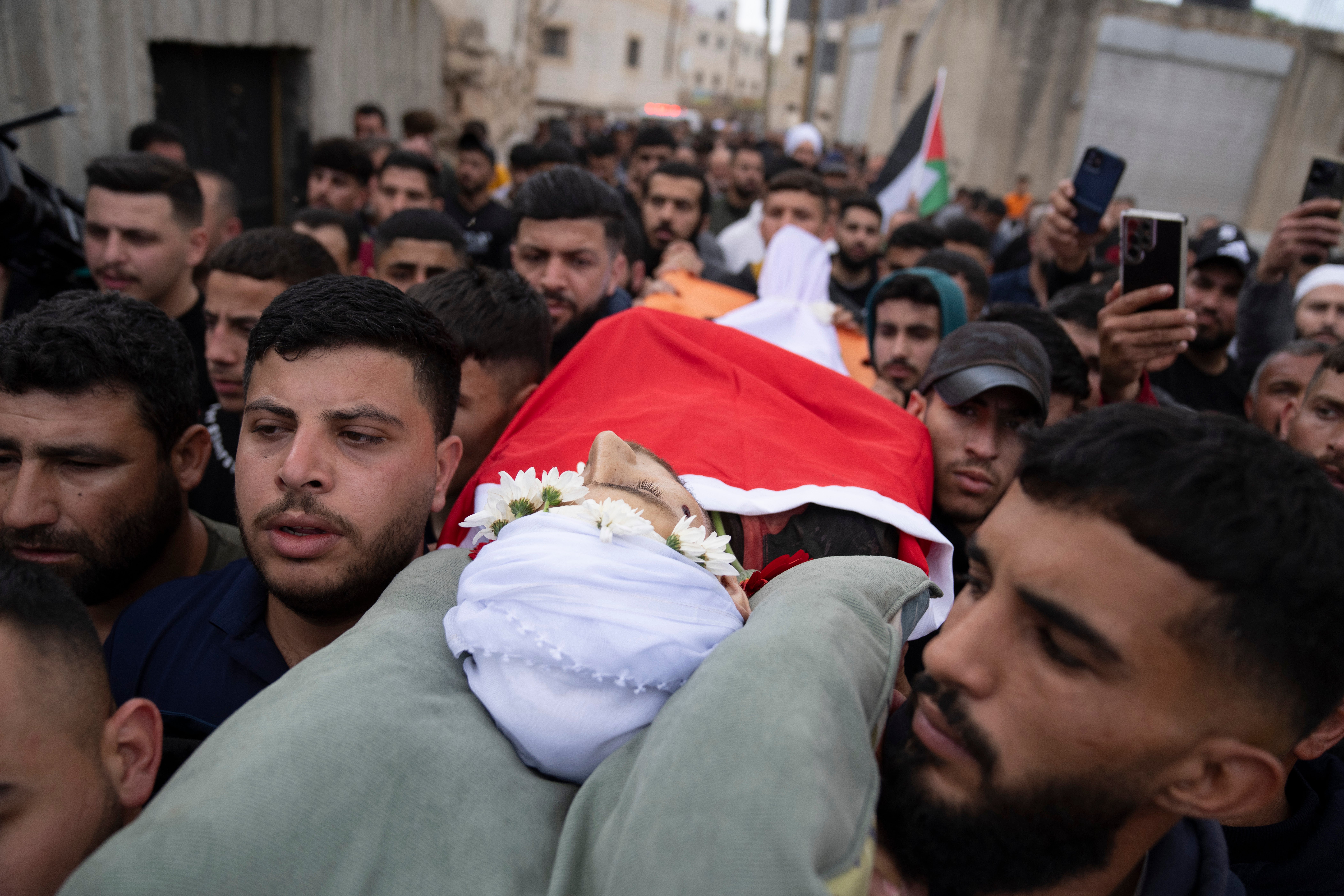 Mourners carry the body of Jehad Abu Alia, who was killed in violence following the death of an Israeli teenager