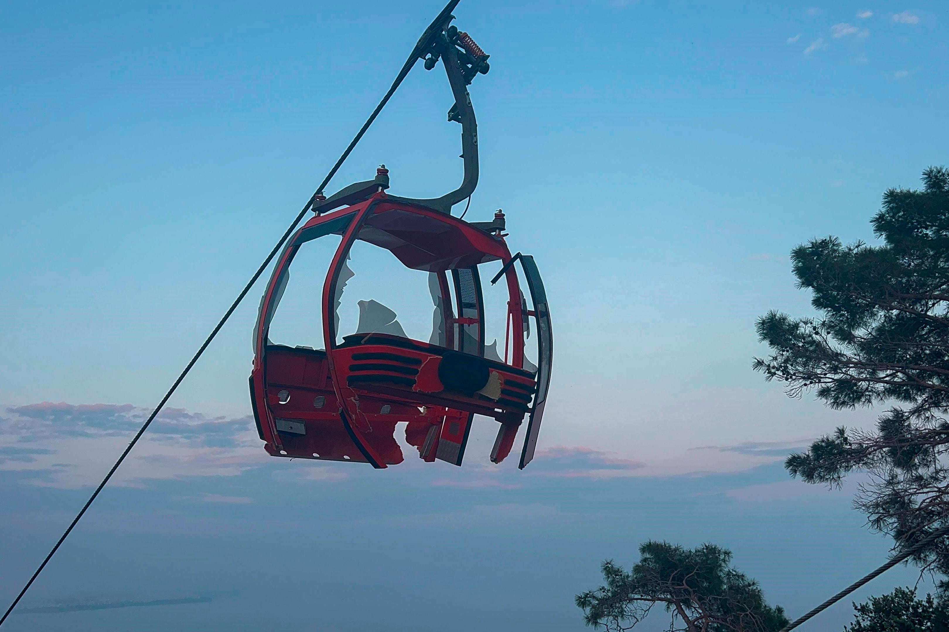 A severely damaged cable car about the mountainside