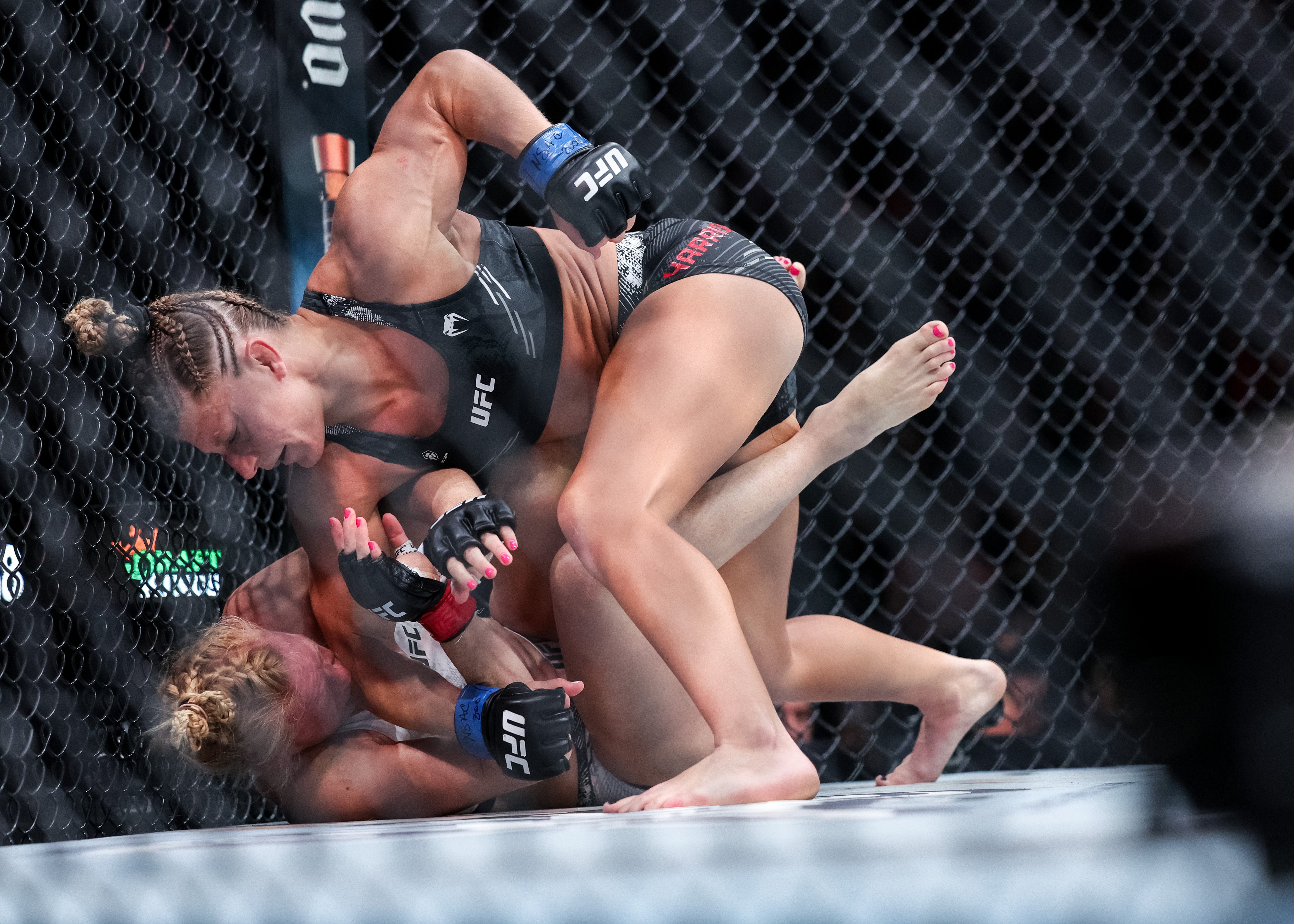 Kayla Harrison (top) en route to a submission win against Holly Holm