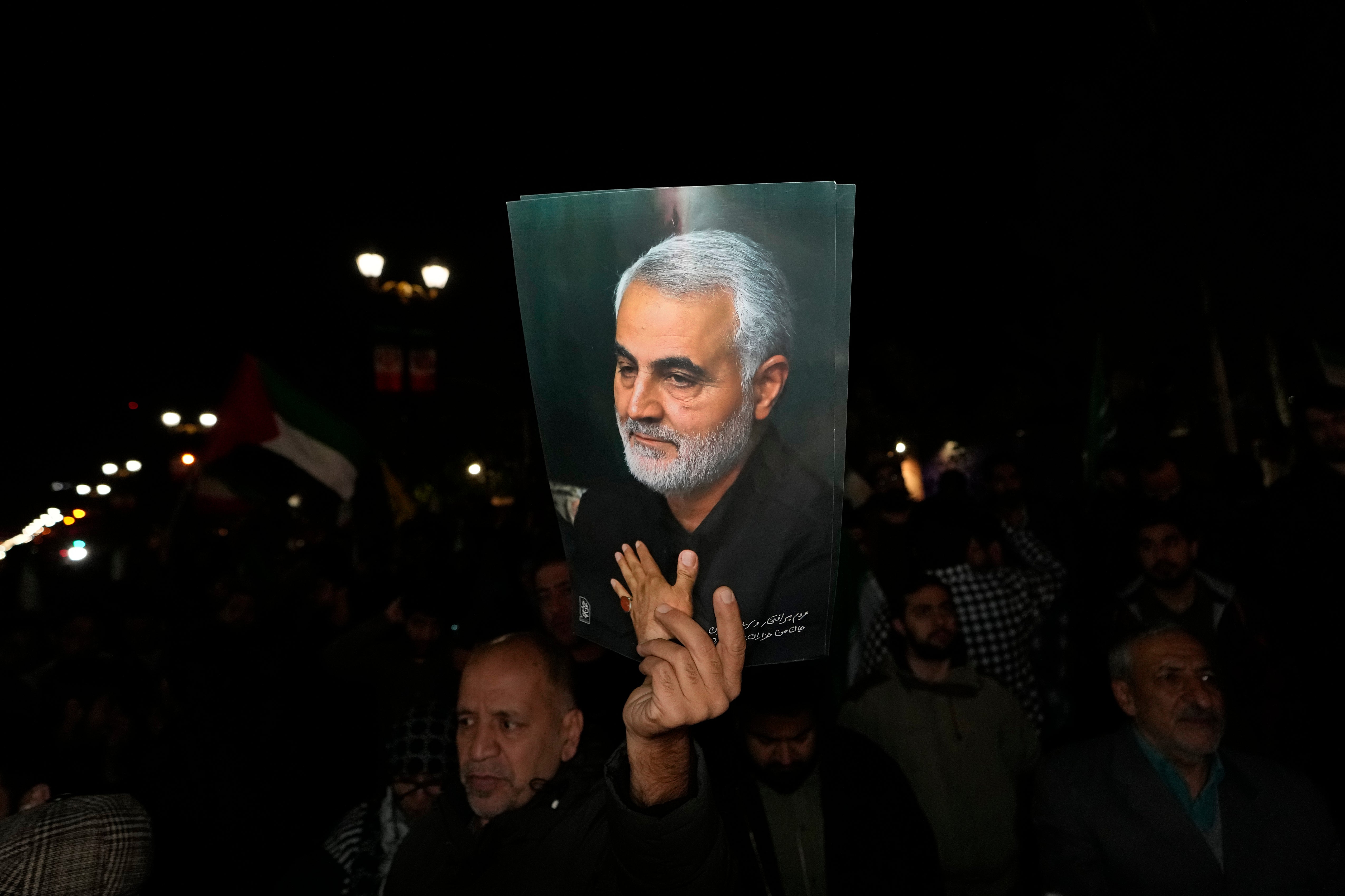 A demonstrator holds up a poster of the late Iranian Revolutionary Guard General Qassem Soleimani, who was killed in a U.S. drone attack in 2020 in Iraq