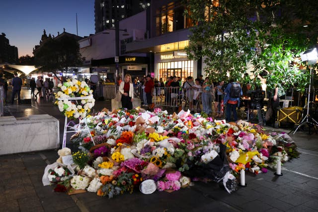<p>A woman leaves flowers outside the Westfield Bondi Junction mall in Sydney on April 14, 2024</p>