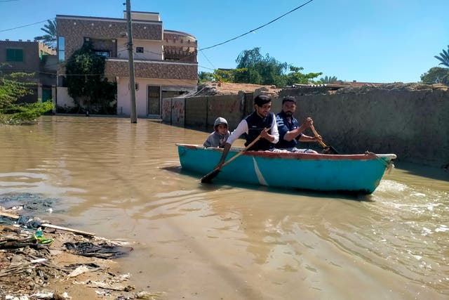 <p>People use a boat to cross a flooded street in Gwadar, Pakistan </p>