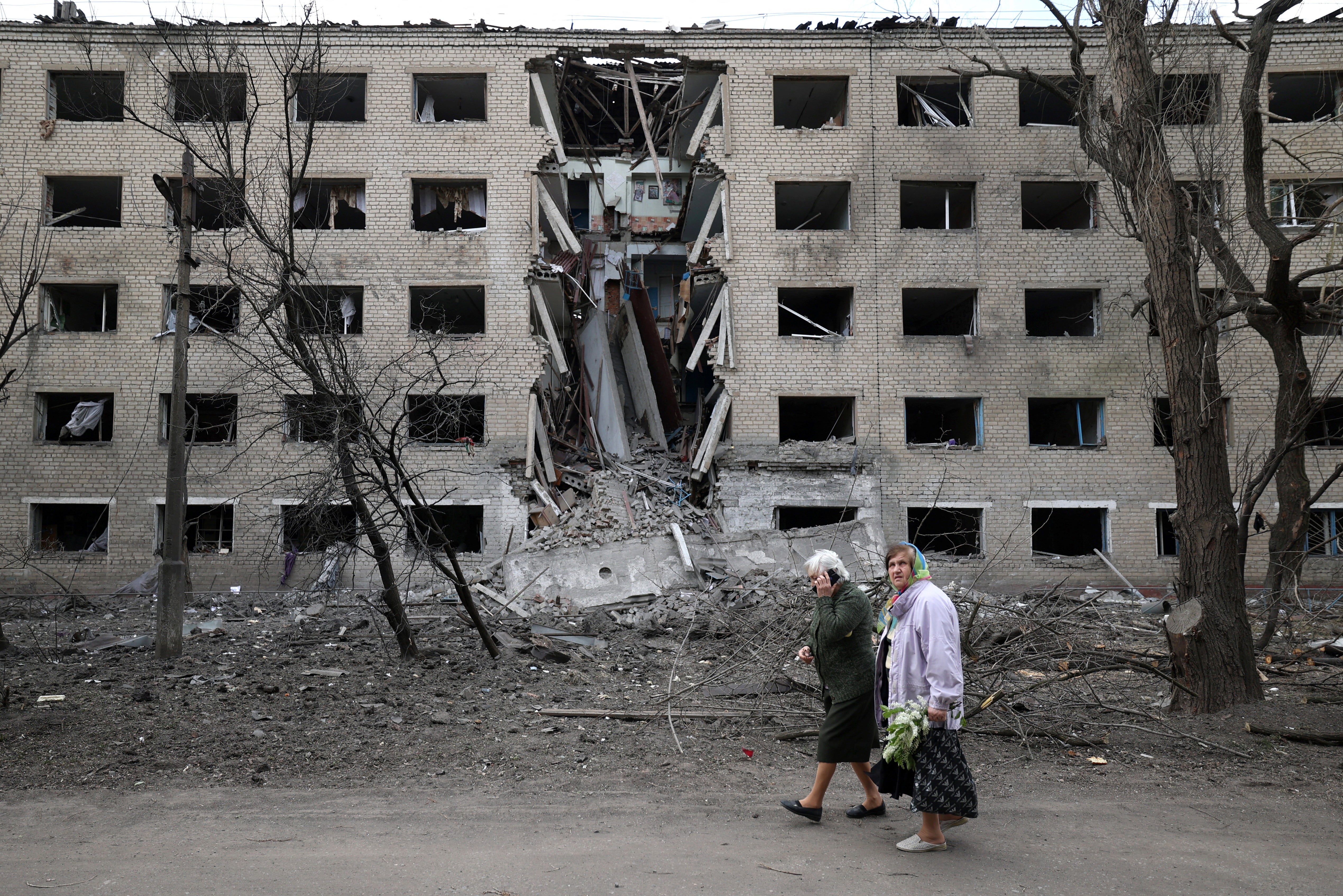 File photo: Elderly women walk past a hostel destroyed during a missile attack in the town of Selydove, Donetsk region