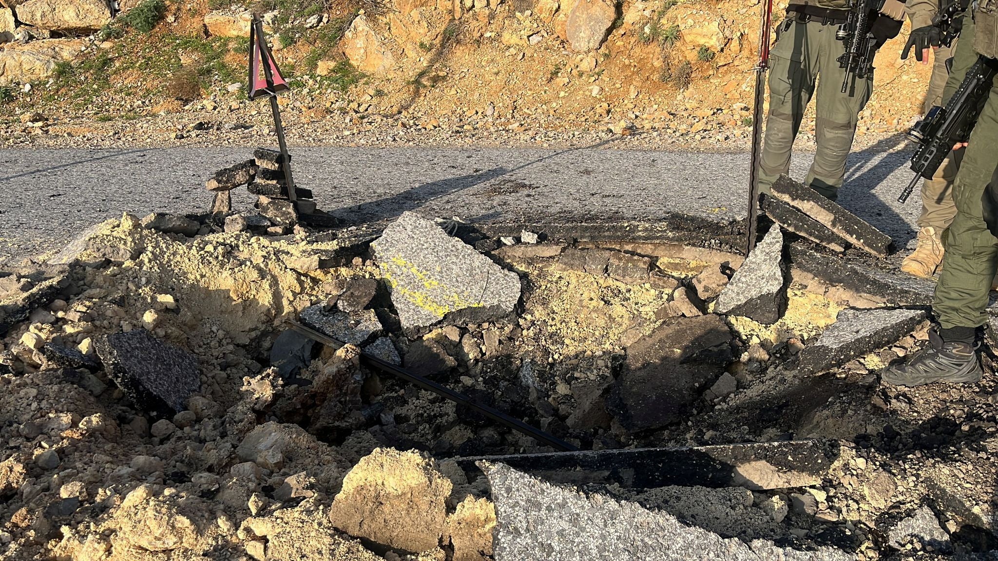 A view of a crater on a damaged road, after Iran's mass drone and missile attack, at a location given as Hermon area, Israel
