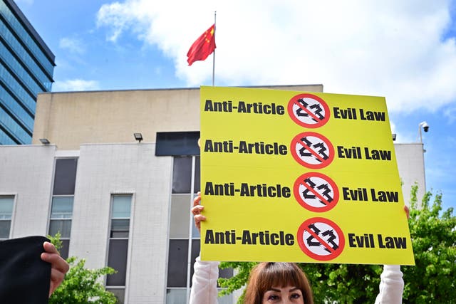 <p>A  person holds a sign during a protest against Hong Kong's new national security law outside the Chinese embassy in Los Angeles </p>