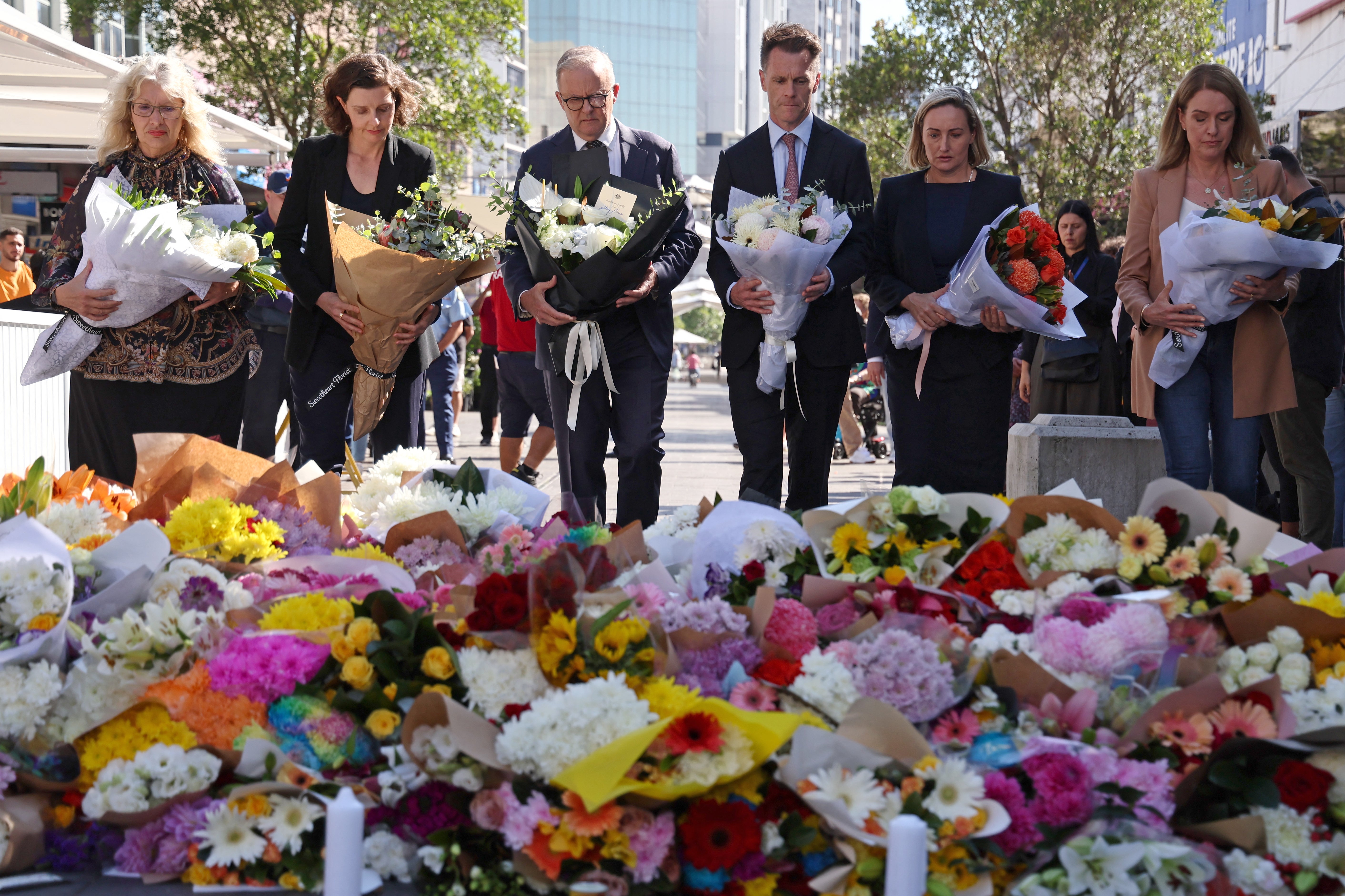 Australian Prime Minister Anthony Albanese and other officials leave flowers outside the Westfield Bondi Junction shopping mall in Sydney