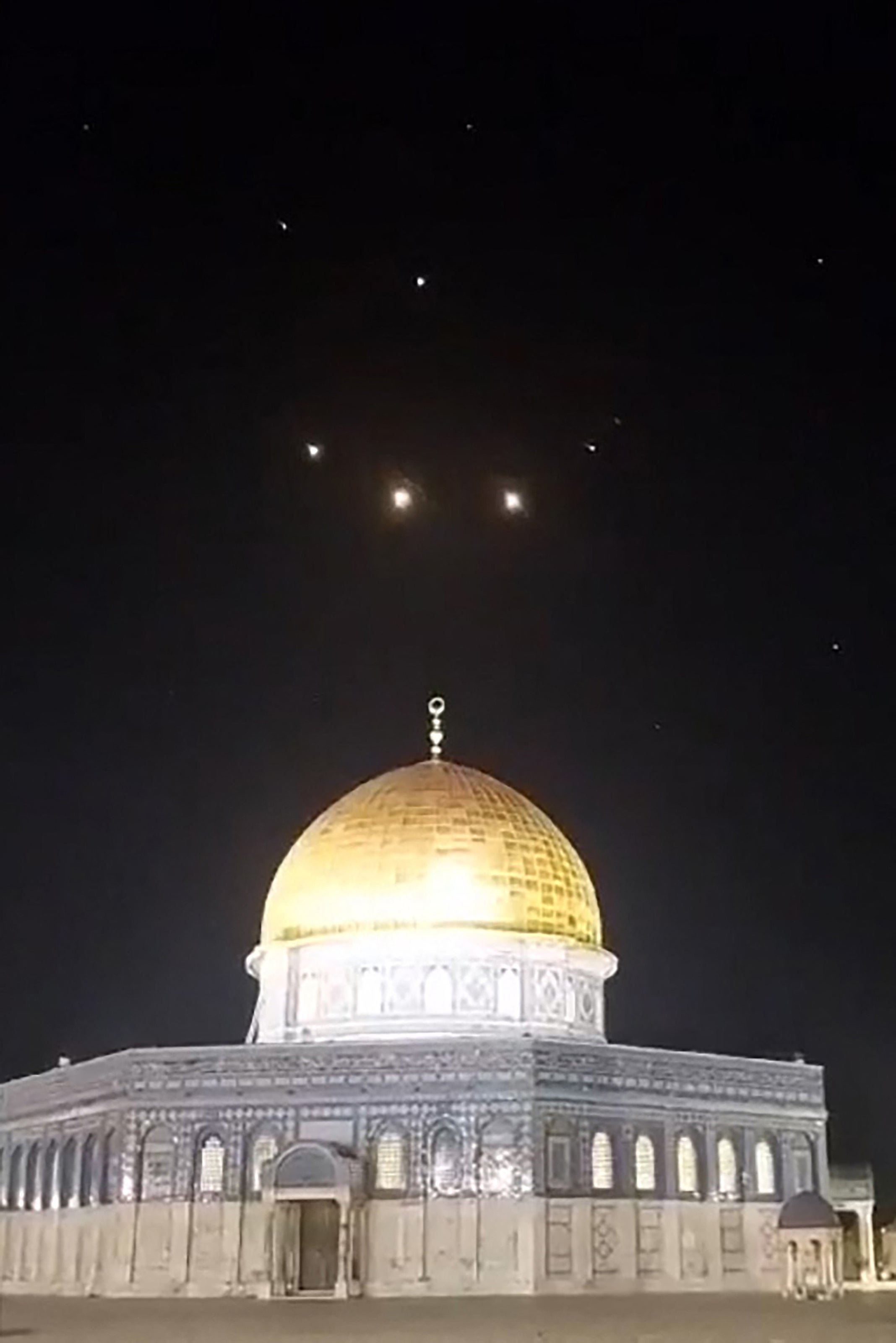 An image-grab from a video taken early on April 14, 2024, shows rocket trails in the sky above the Al-Aqsa Mosque compound in Jerusalem.