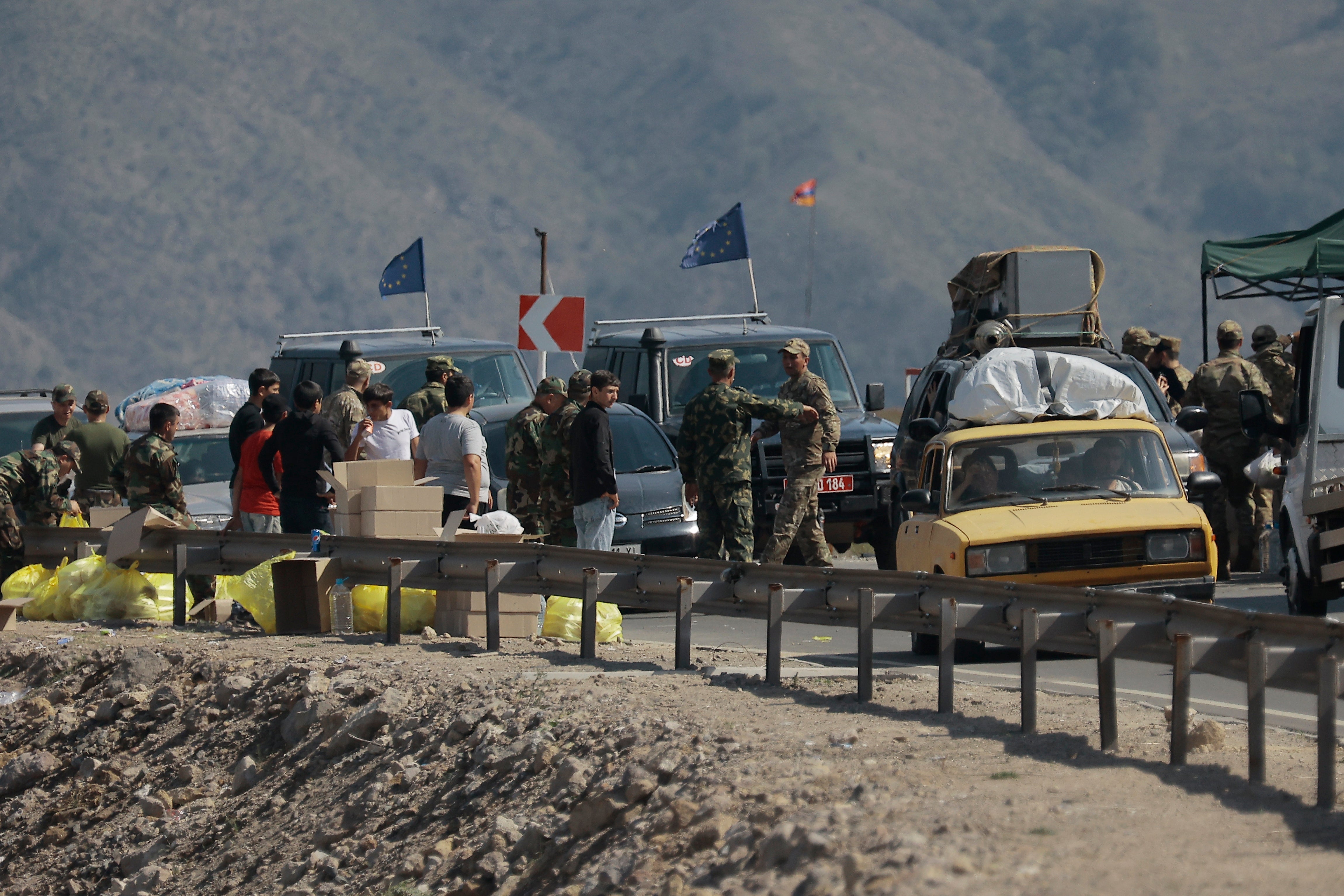 Ethnic Armenians from Nagorno-Karabakh and European Union observers drive their cars past a checkpoint on the road from Nagorno-Karabakh to Armenia’s Goris