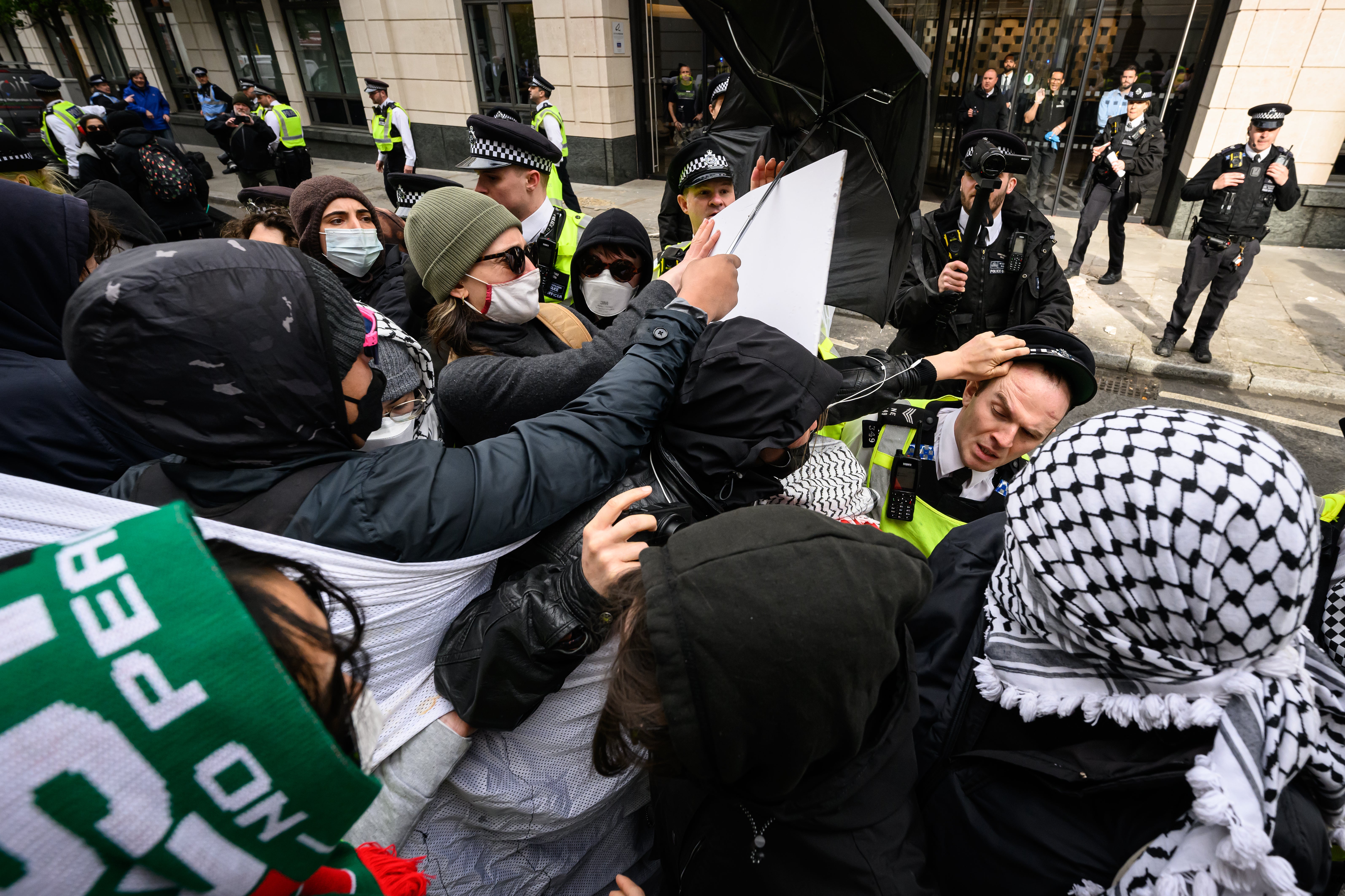 Protestors scuffle with the police as they are moved from the entrance to One Curzon, a building owned by property company London Metric, who also rent buildings to weapons manufacturers Elbit, Boeing and BAE Systems, on April 15, 2024 in London