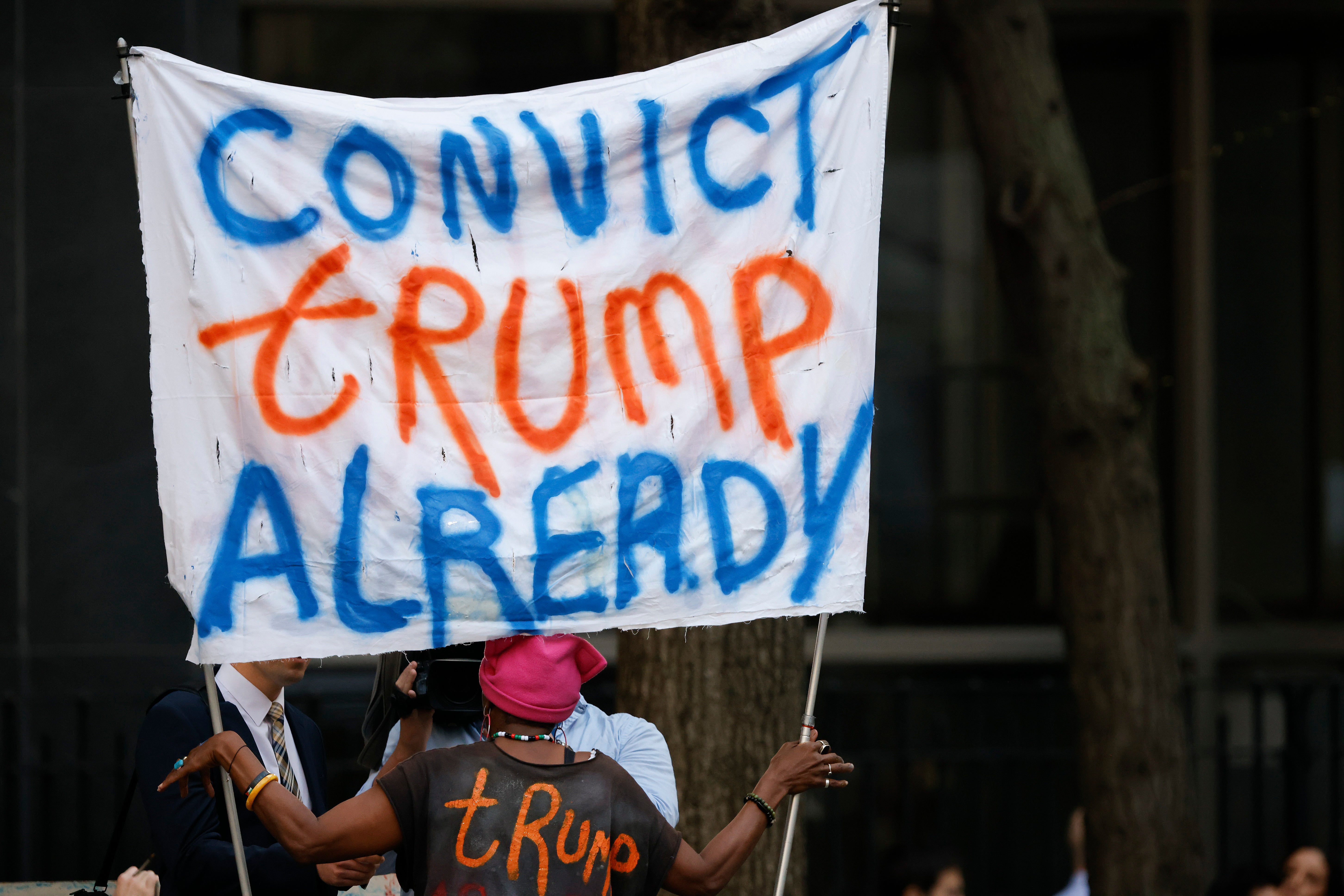 Protestor holds up a sign that reads ‘Convict Trump Already’