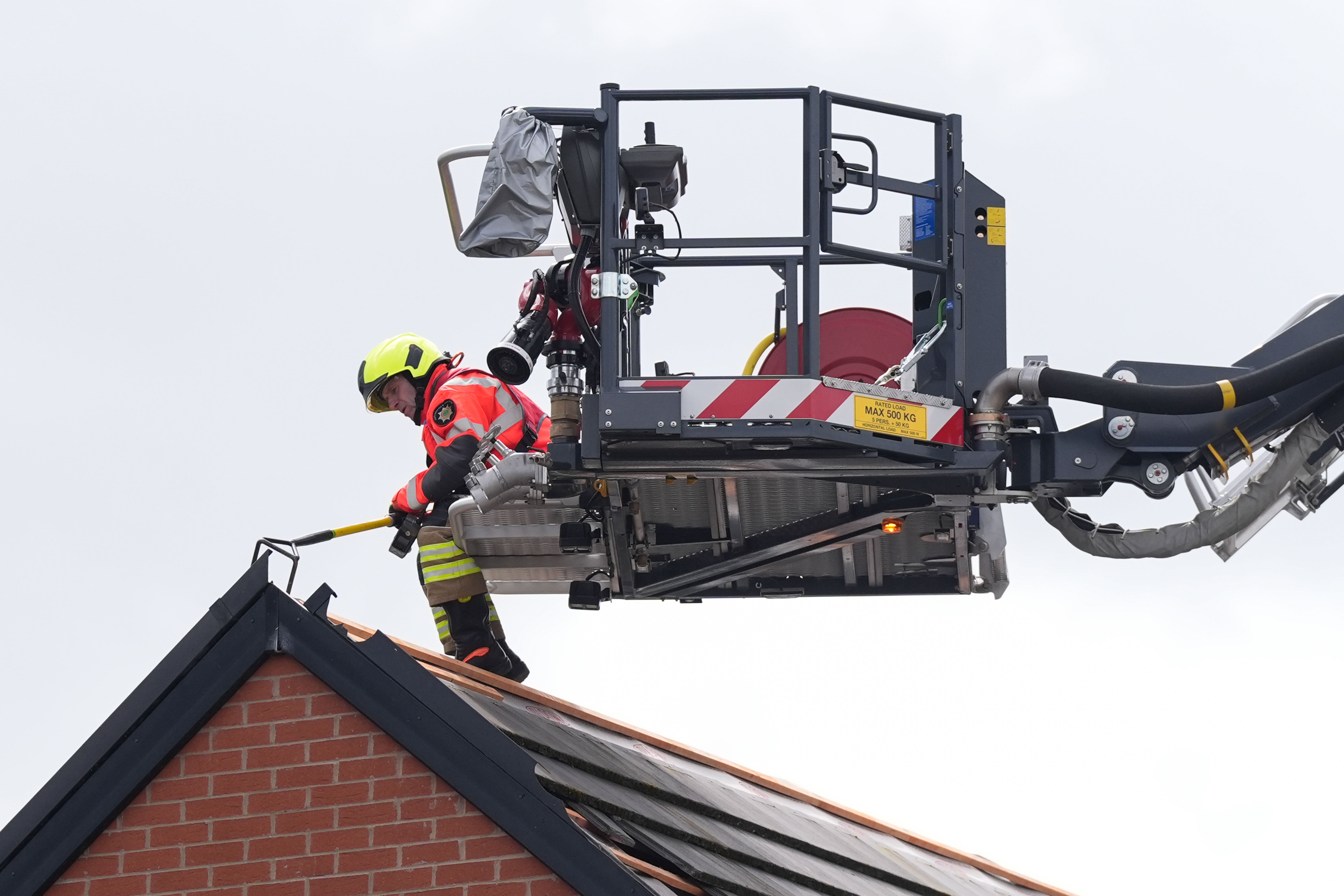 Emergency service workers inspect the roof a property in Knutton, North Staffordshire