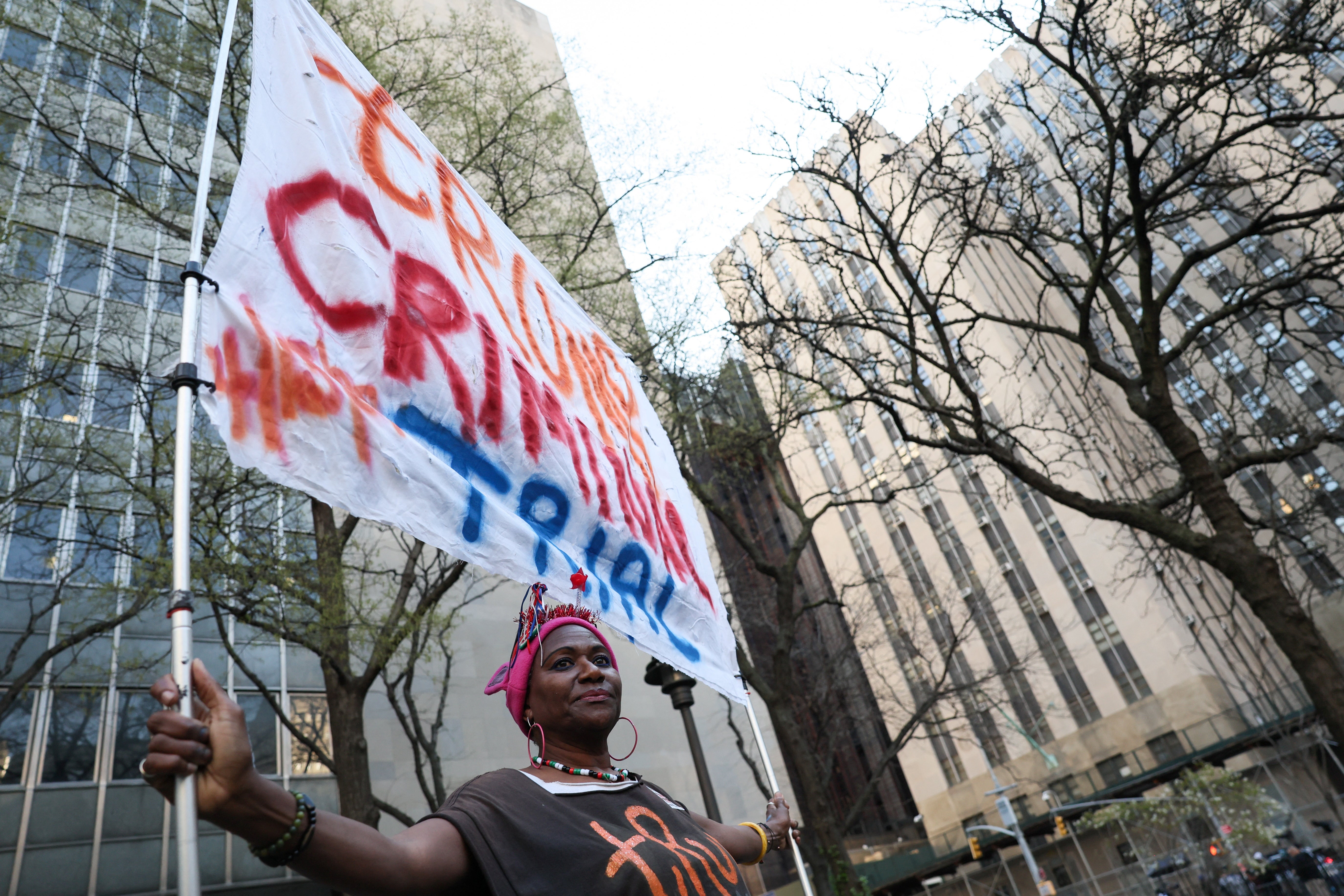 A protester holds a banner against Donald Trump outside the courthouse