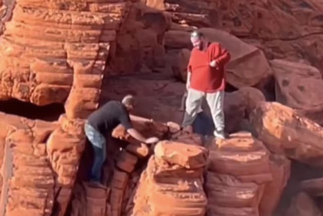 <p>Video footage shows two visitors scaling red rock formations and  shoving large chunks to the ground in Lake Mead National Park </p>