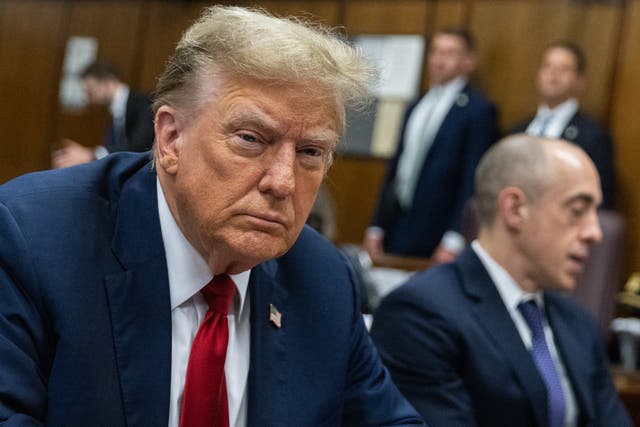 <p>Donald Trump scowls as he sits at the defence table during day one of his first criminal trial in New York on 15 April. </p>