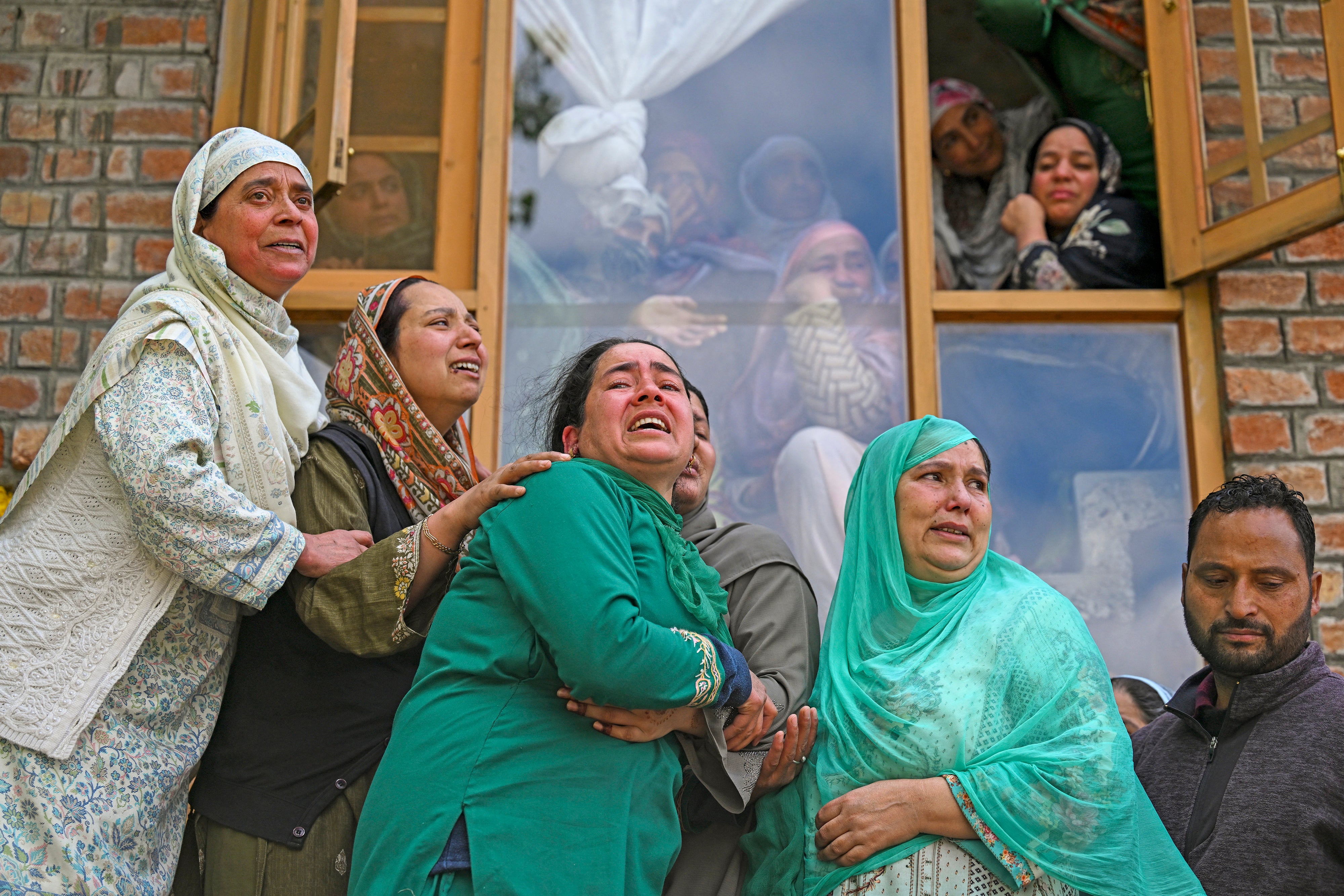 People mourn at the funeral of their relatives who died after a boat overturned in the Jhelum river