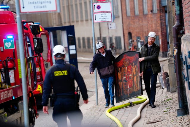 <p>A painting is salvaged from the flames of the Boersen stock exchange building in Copenhagen during Tuesday’s fire</p>