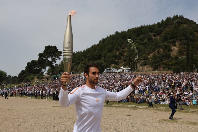 <p>Greek rower Stefanos Ntouskos carries the Olympic Flame during the start of the torch relay for the Paris 2024 games</p>