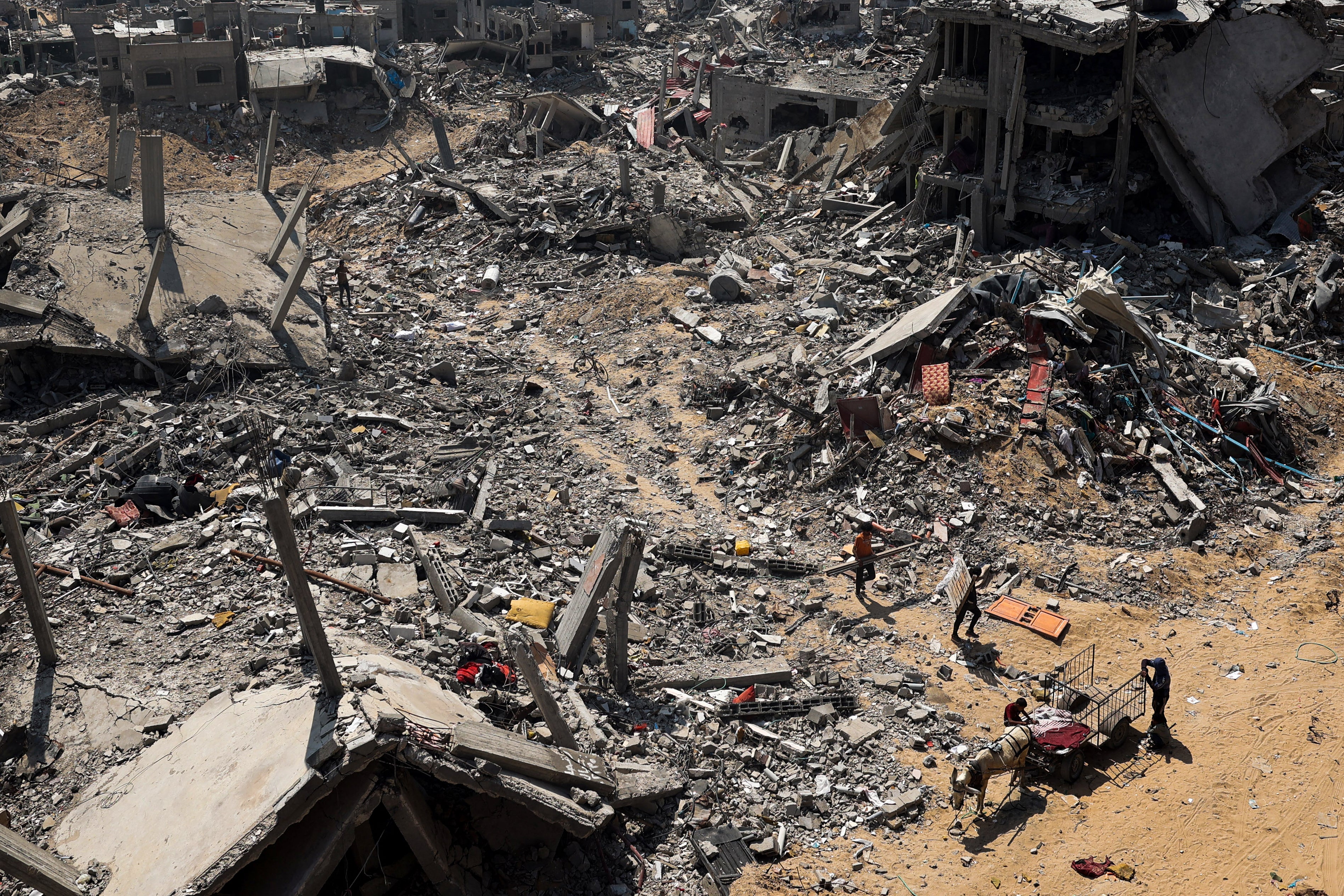 People look for salvageable items amid the rubble of buildings destroyed during Israeli bombardment in Khan Yunis, on the southern Gaza Strip on April 16, 2024, as fighting continues between Israel and the Palestinian militant group Hamas.