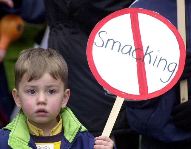 <p>A young child holds an anti-smacking placard at a protest over the controversial issue </p>