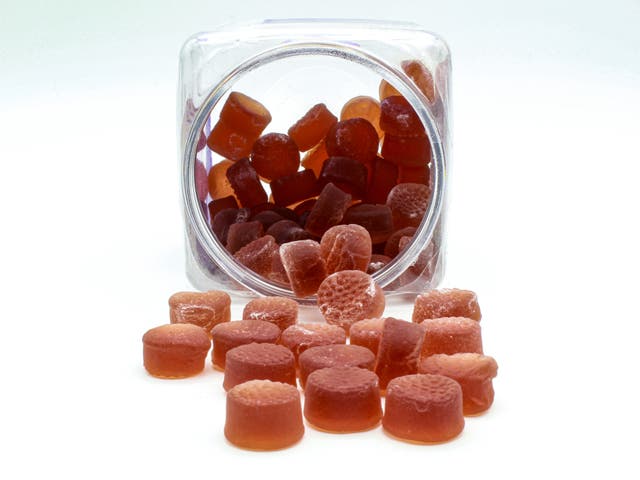 <p>A jar of red melatonin gummy supplements</p>