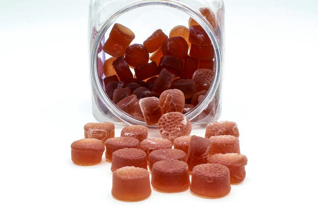 <p>A jar of red melatonin gummy supplements</p>